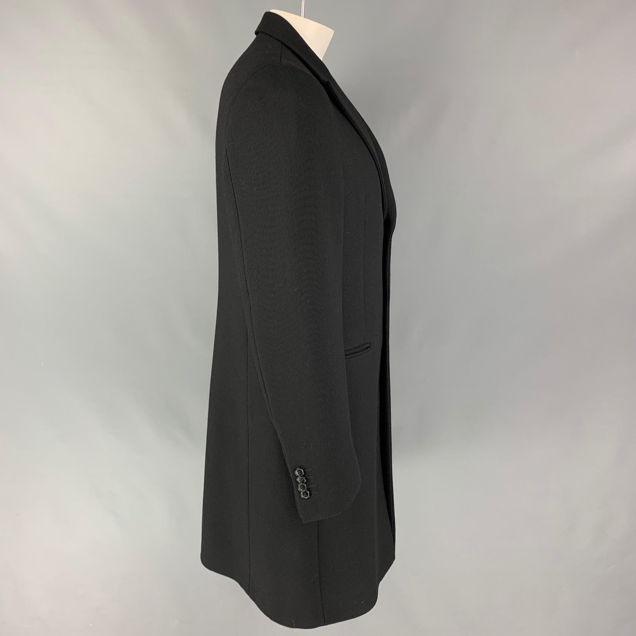 EMPORIO ARMANI coat comes in a black wool / polyamide with a full liner featuring a peak lapel, slit pockets, single back vent, and a three button closure. Made in Italy.
Very Good
Pre-Owned Condition. 

Marked:  44 

Measurements: 
 
Shoulder: 18.5