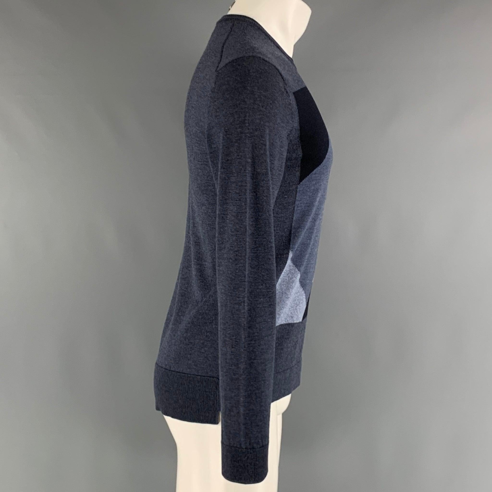 Ce pull-over EMPORIO ARMANI en tricot de laine gris et anthracite présente un style color block, un panneau arrière plus long, un ourlet côtelé et une encolure ras du cou. Excellent état d'origine. 

Marqué :   S 

Mesures : 
 
Épaule : 18 pouces
