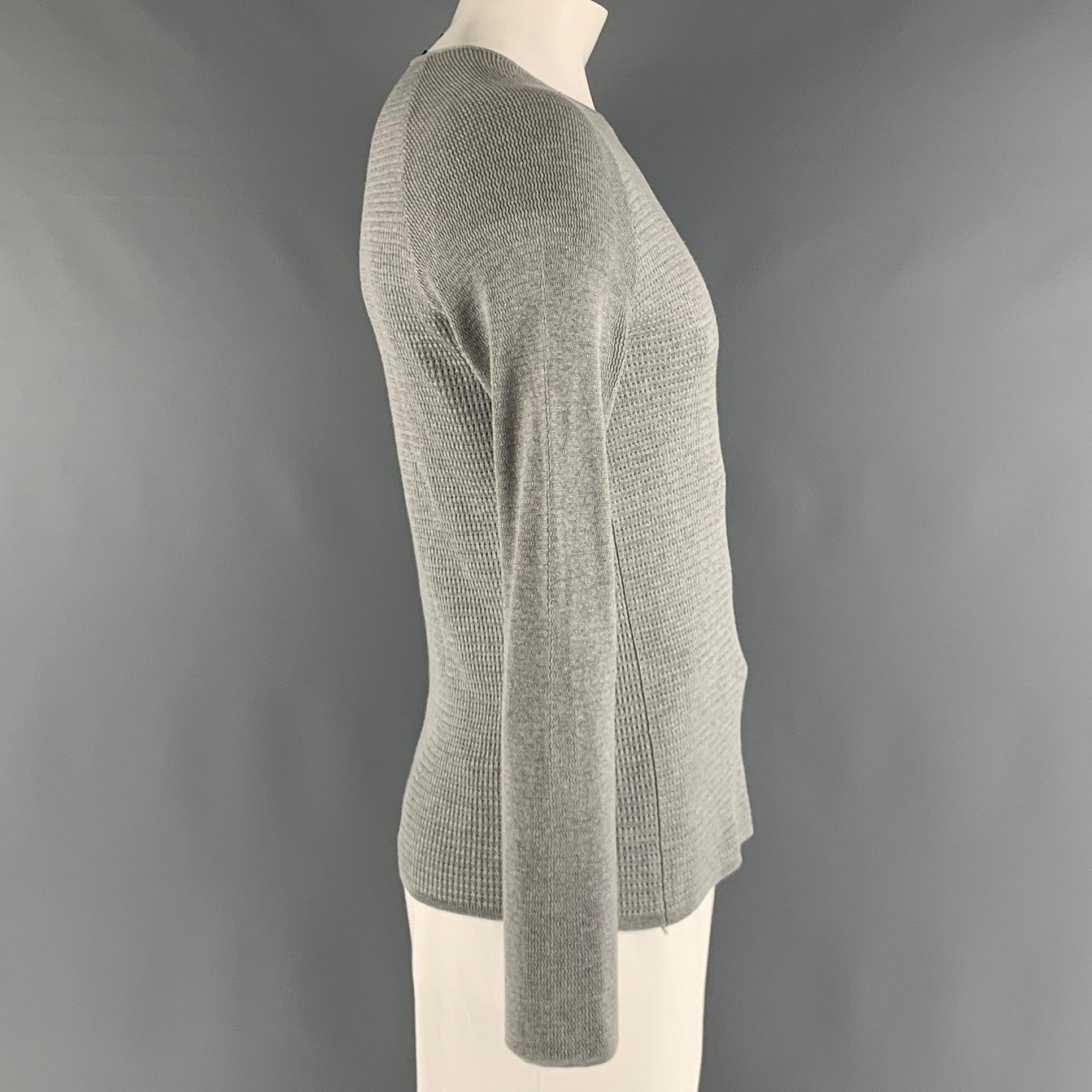 EMPORIO ARMANI raglan pullover comes in a grey wool open knit featuring a ribbed hem, and a boat neck. Very Good Pre-Owned Condition. Minor mark at right sleeve. 

Marked:   48 

Measurements: 
 
Shoulder: 17 inches Chest: 40 inches Sleeve: 25.5