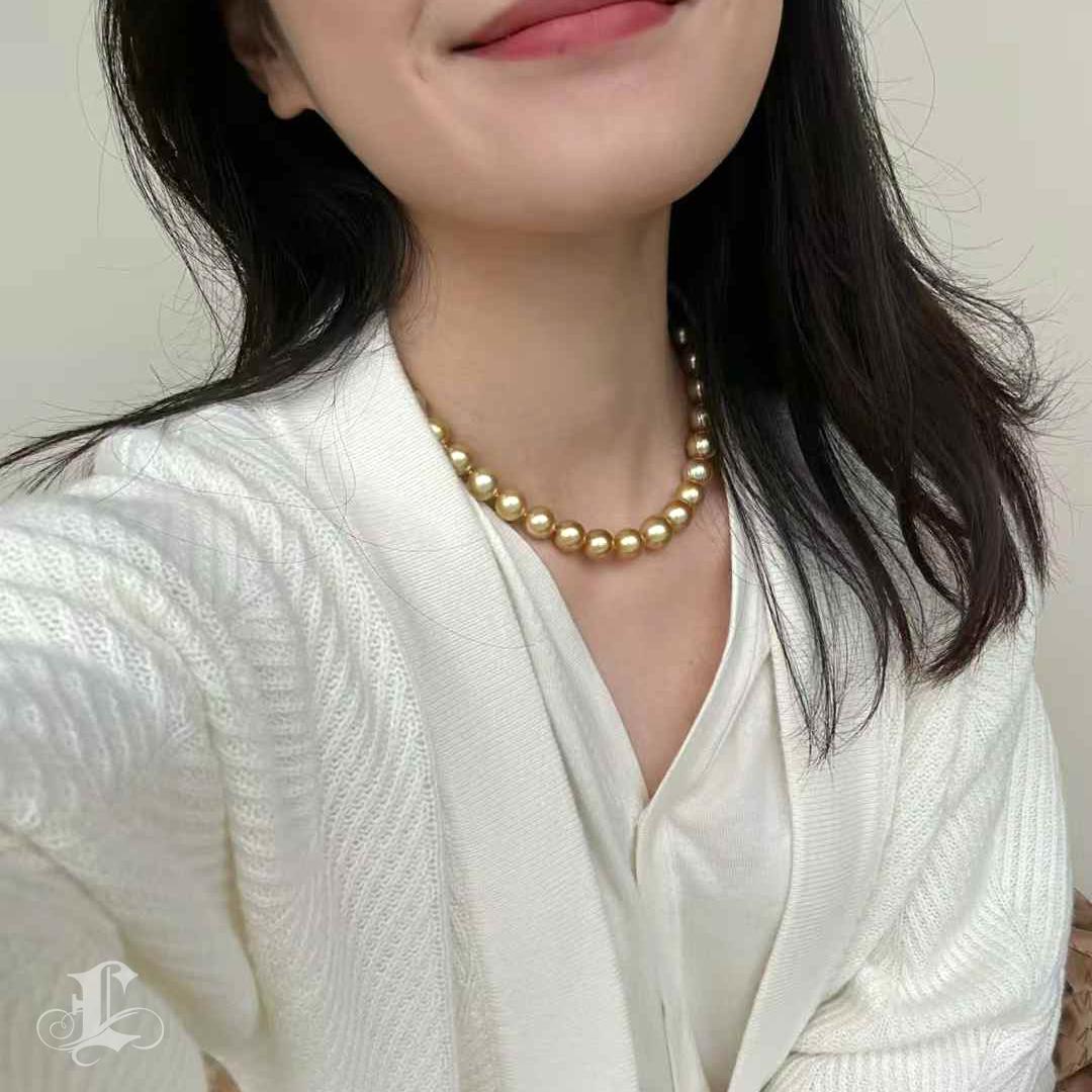 Este majestuoso collar contiene perlas doradas redondas de los Mares del Sur de 10-11 mm de la mejor calidad, cada una de ellas con un extraordinario brillo de espejo, un intenso tono dorado y una superficie extremadamente limpia. Ligeramente