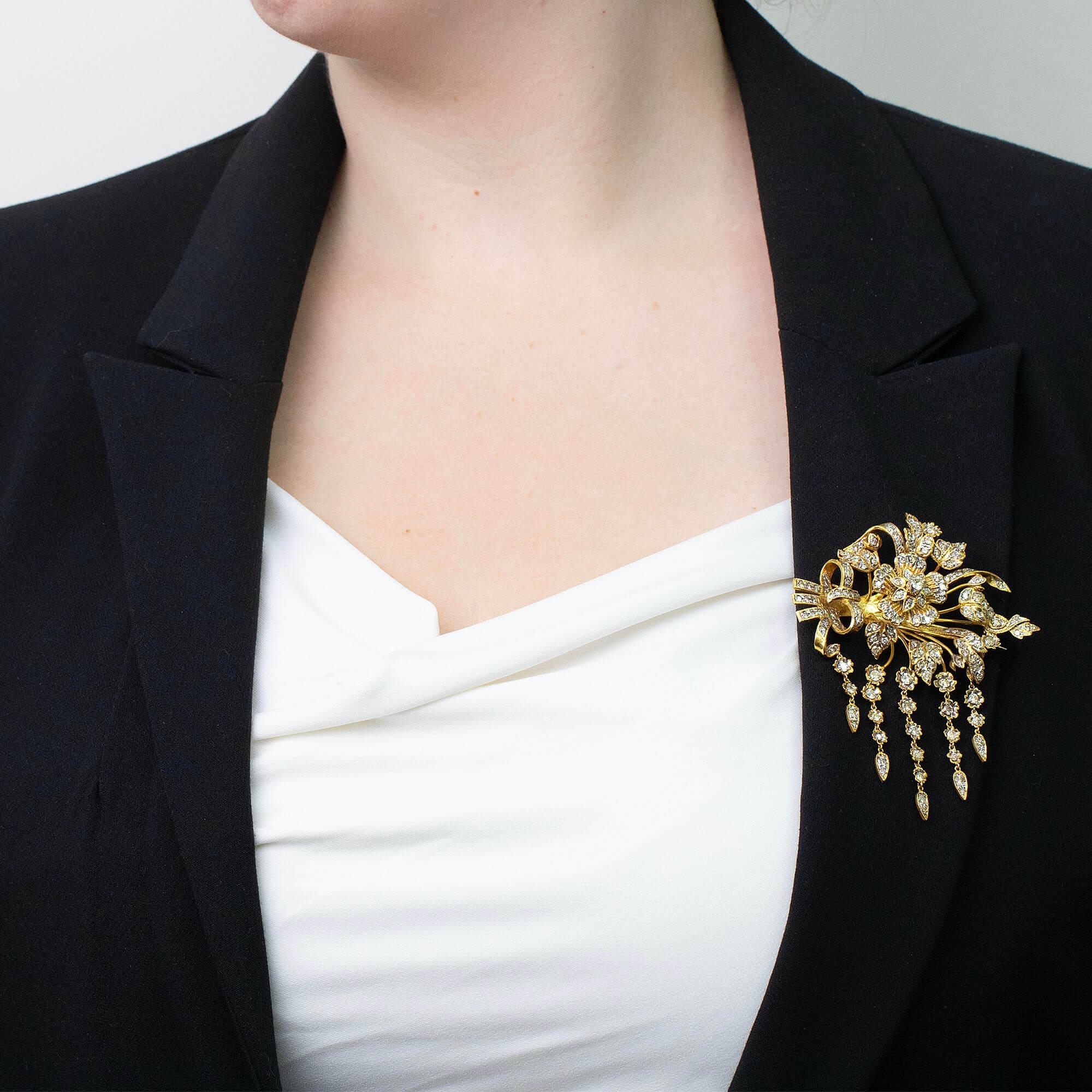 Cette magnifique broche est une reproduction de la fin du 20e siècle des broches de style En Tremblant des années 1880. Réalisée en or jaune et sertie de diamants ronds de taille brillant, cette broche présente une fleur centrale en relief 