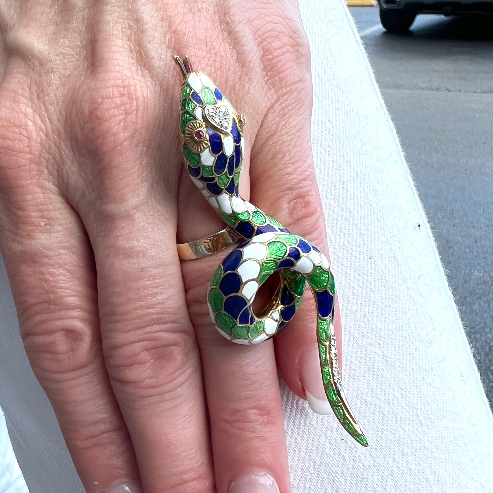 Fabulous statement snake ring crafted in colorful enamel and 18 karat yellow gold. The snake features diamond and ruby accents together with colorful blue, green, and white enamel. The snake measures 1.00 x 3.00 inches, and is currently size 6.5