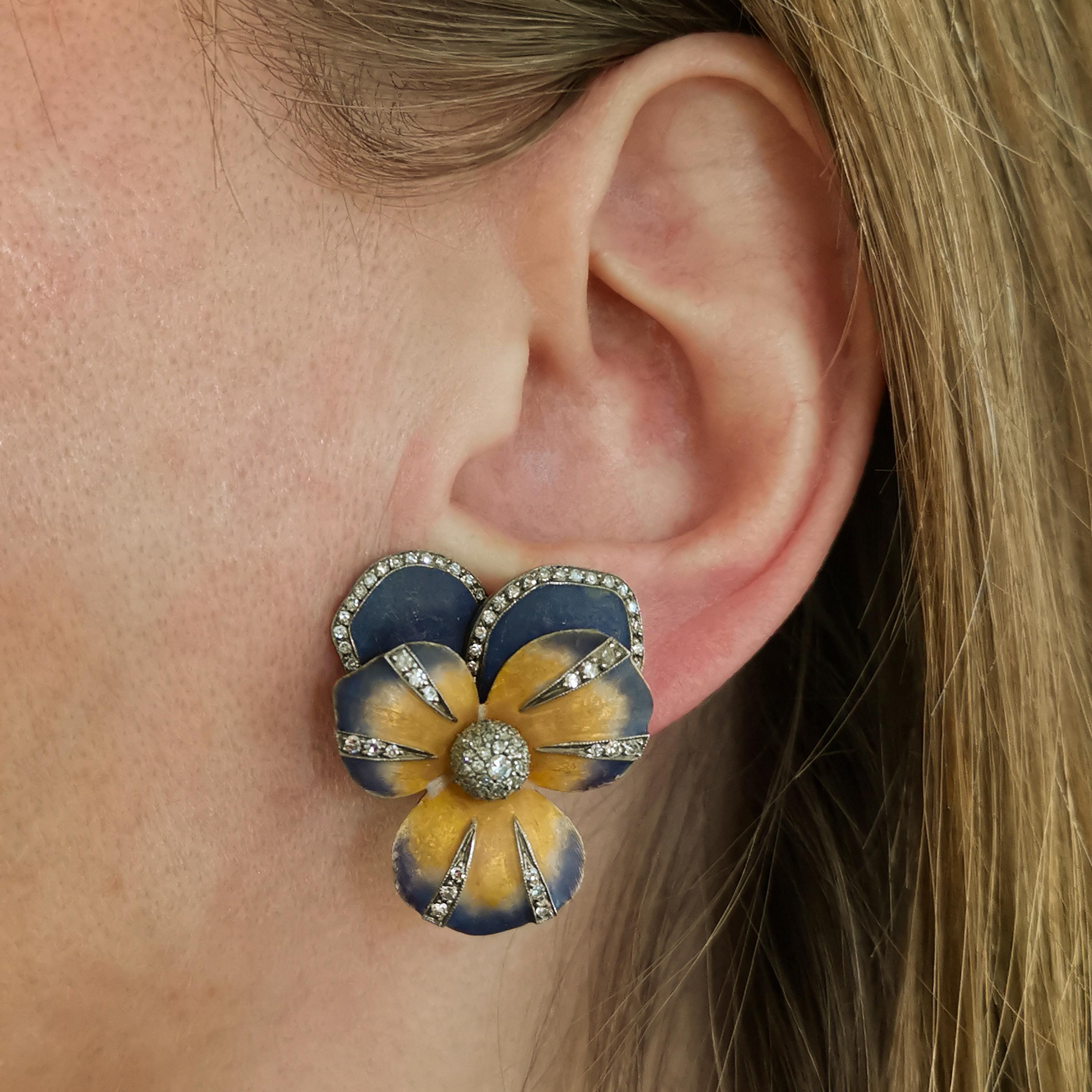 A pair of Moira pansy earrings, with purple and yellow matt basse-taille enamel, and pavé set eight-cut diamonds, mounted in gold with silver settings, signed Moira and numbered. With collapsible posts and clip fittings.

Moira's eponymous