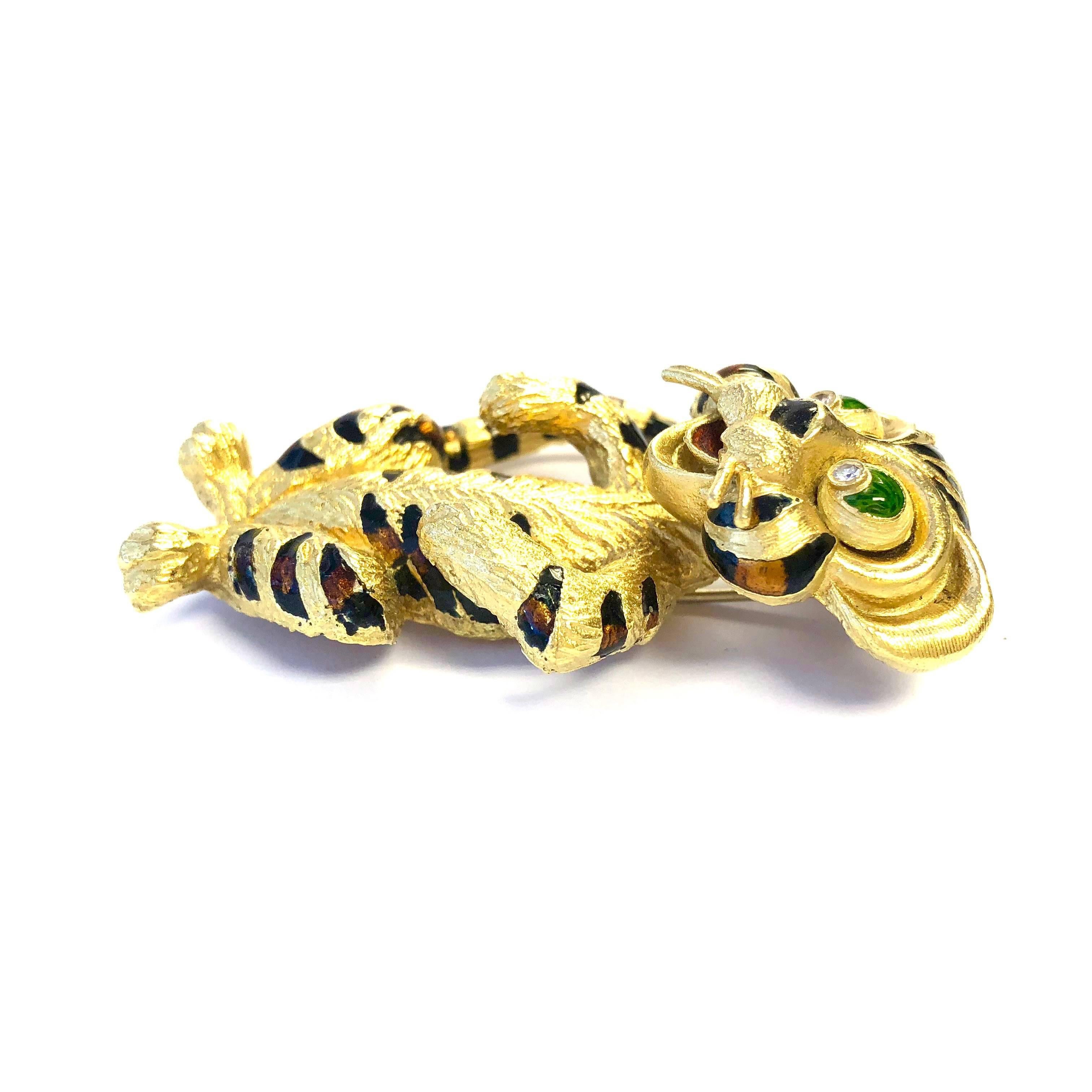 Crafted in 18K yellow gold, featuring a large three dimentional design tiger cub with diamond and enamel eyes and enamel stripes. 
The brooch measures: 2 1/4 inch heigh (57 mm), 7/16 inch wide (37 mm) and 11//16 inch deep (17.5 mm).
Weight: 34.6