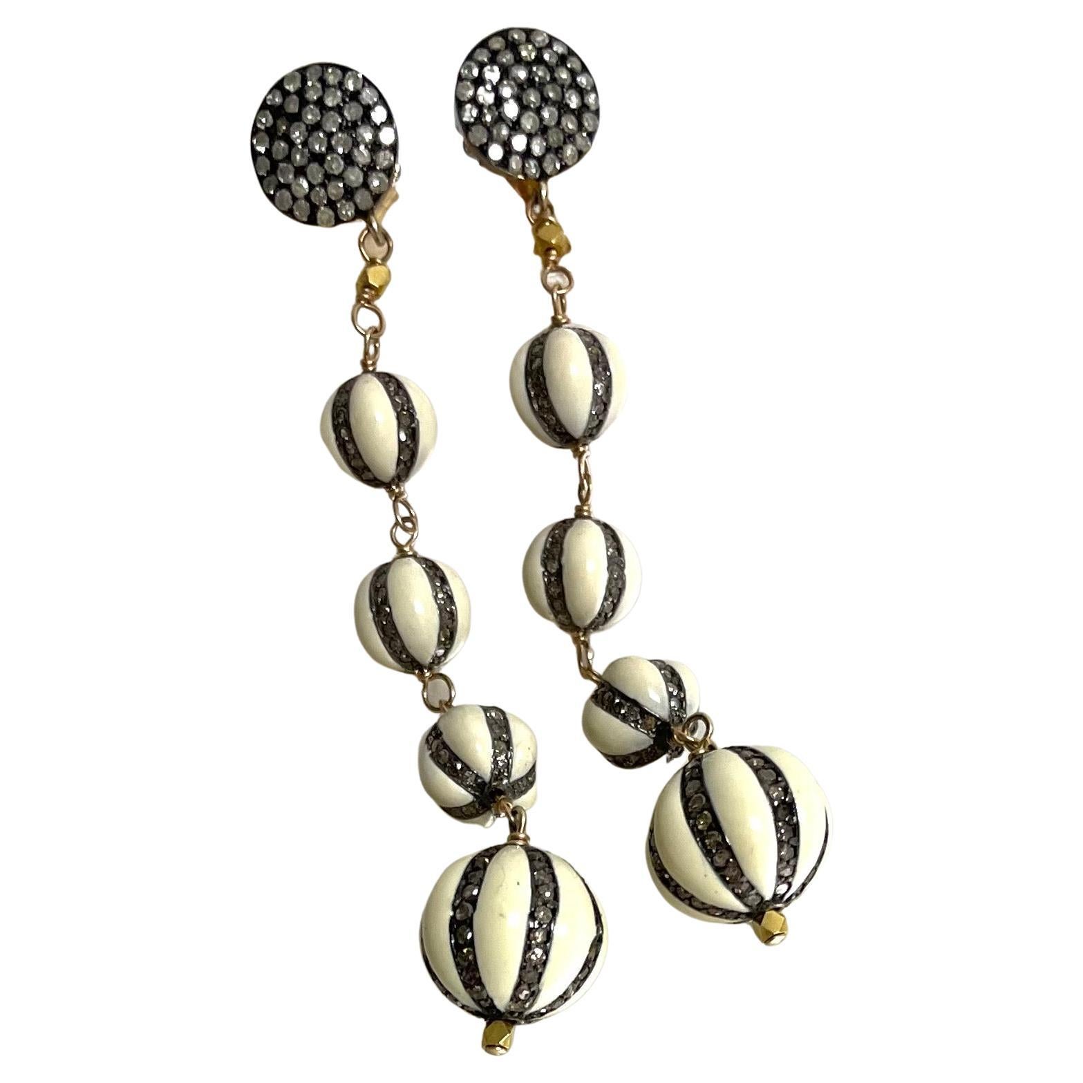 Description
Whimsical enamel and pave diamond melon ball design earrings.
Item # E3008

Materials and Weight
Ivory color Enamel 8 and 12.5mm, round shape
Pave diamonds 
18k yellow gold faceted beads
Rhodium sterling silver
14k posts and jumbo back