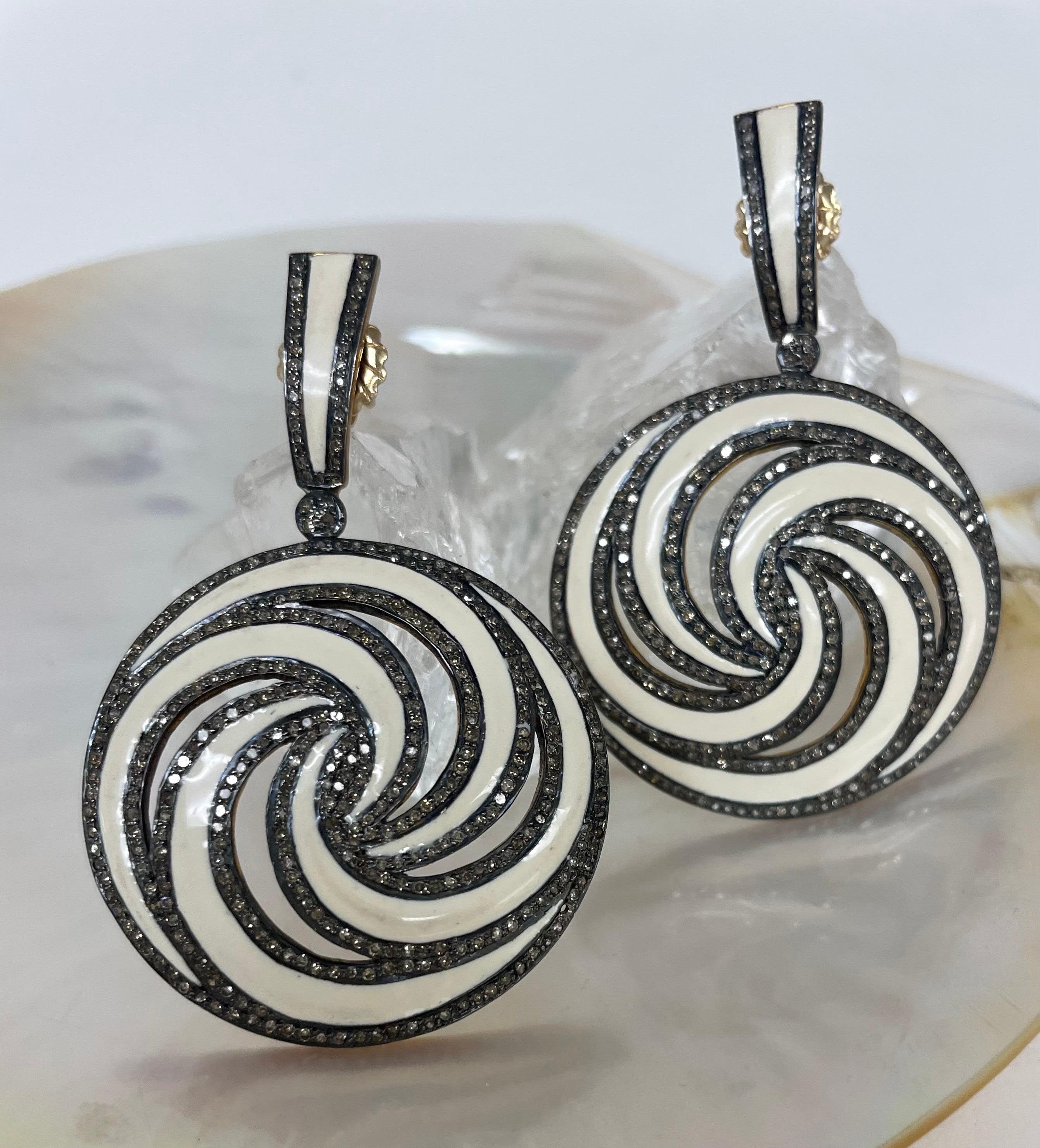 Description
Stylish enamel and pave diamond pinwheel design statement earrings.
Item # E2705

Materials and Weight
Ivory color Enamel 40 mm, round 
Pave diamonds 
Rhodium sterling silver
14k posts and jumbo backs

Dimensions 
Length 2 inches

Made