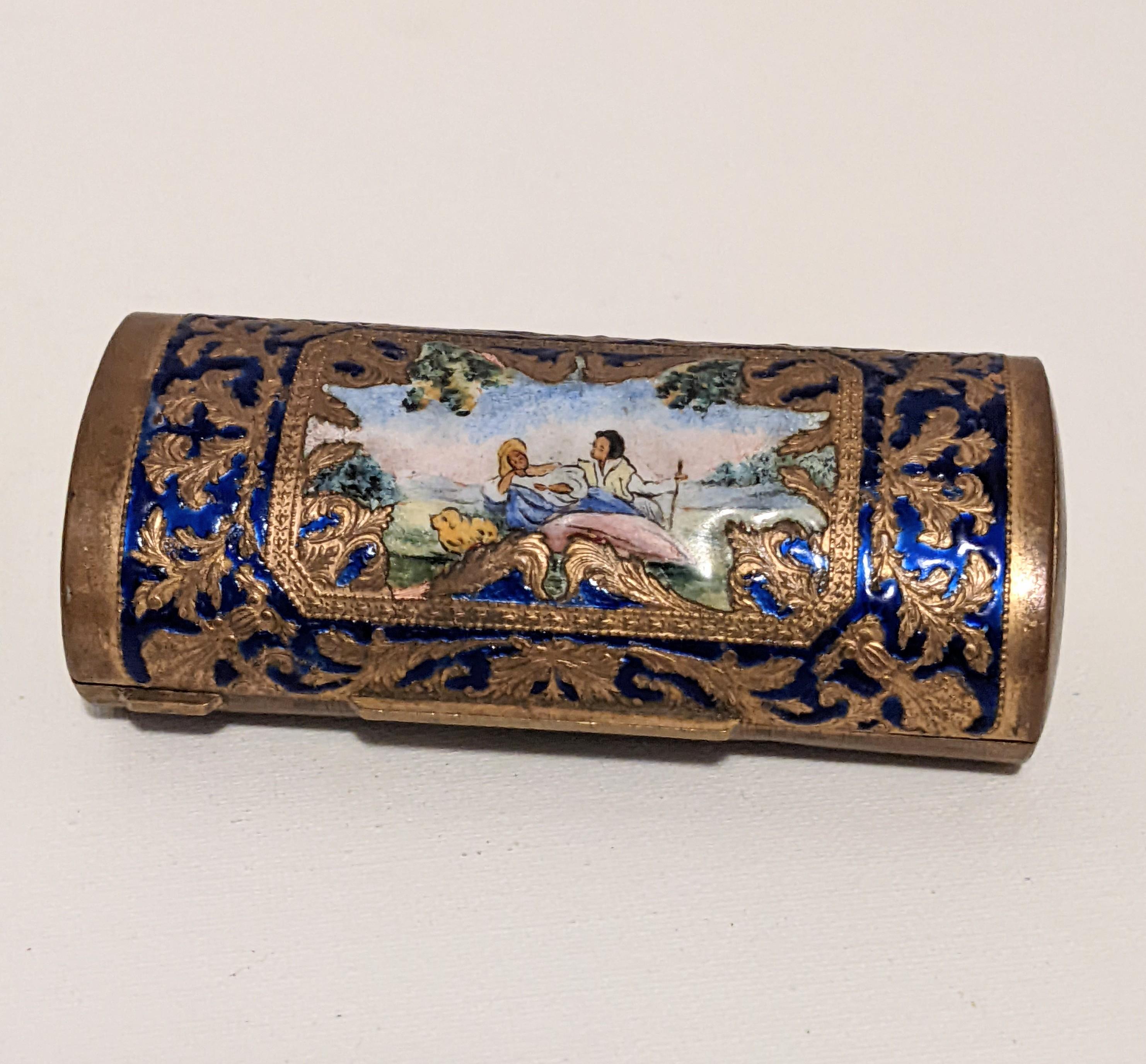 Charming Enamel Brass Pillbox or cigarette case with pastoral scene on hinged cover set within deep blue enamel scrollwork. Best for use as decorative desk piece or can be used in a purse within a felt pouch as enamel is delicate. 
1950's Italy.  4