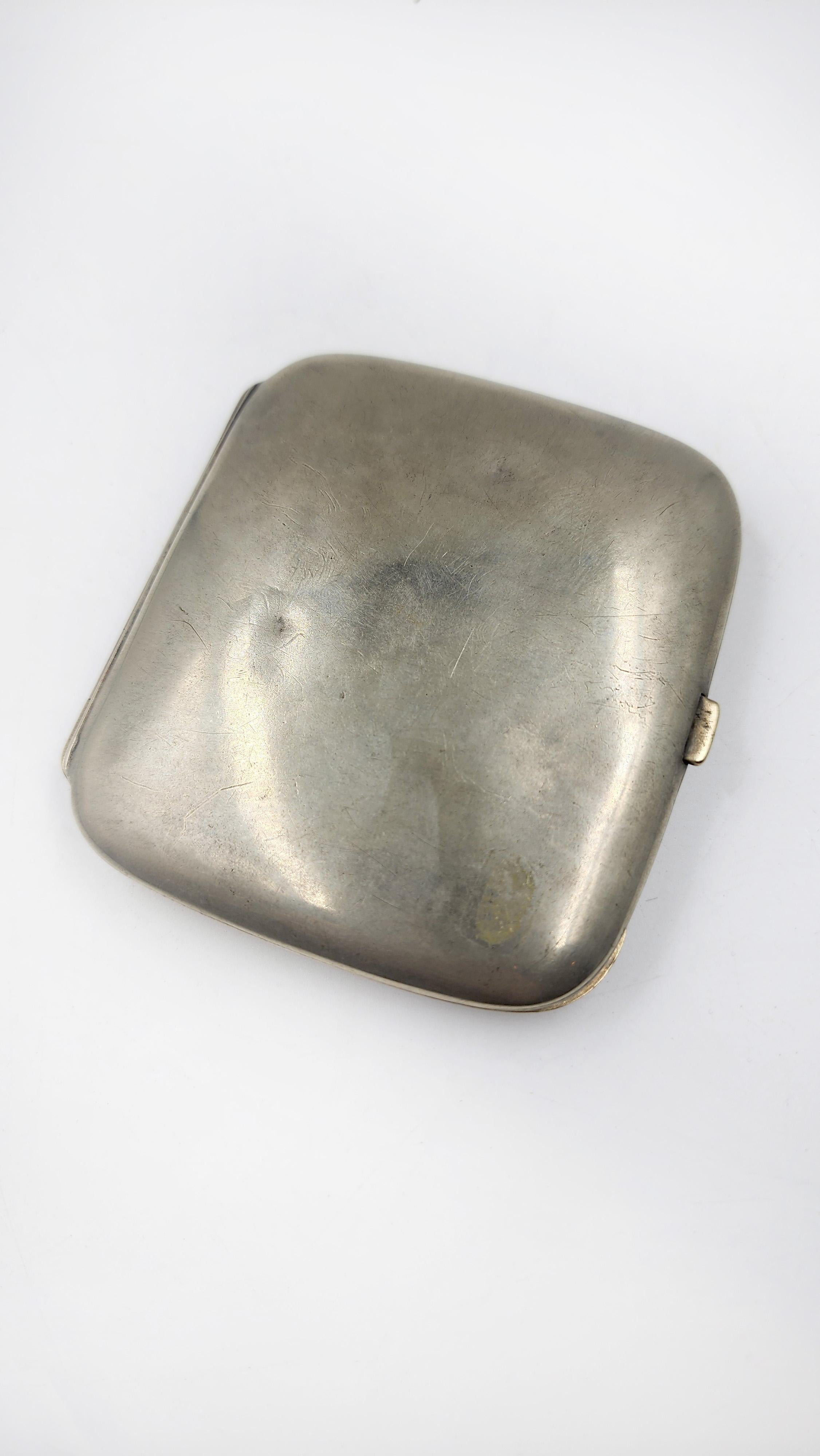 Enamel Cigar Case with Hunting Dog Design
Elegant vintage cigar case, rectangular with rounded corners, and a silver-plated finish. The lid is adorned with a hand-painted enamel plaque depicting a hunting scene with three English Setter dogs in a