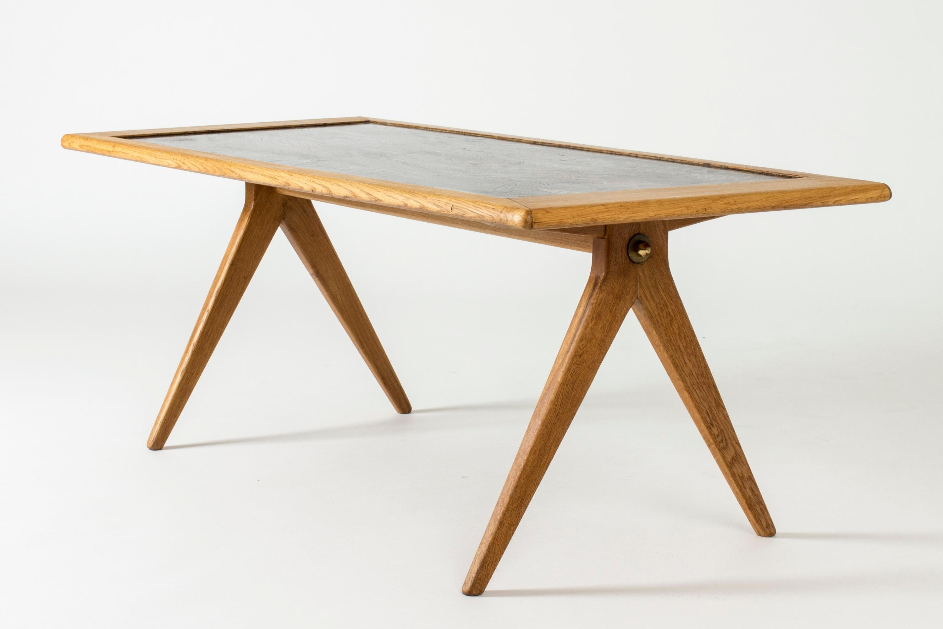 Table basse de Stig Lindberg, conçue pour NK. Remarquable plateau de table en émail avec un motif sous-marin ondulant dans des tons rouges, placé dans un élégant cadre en chêne.