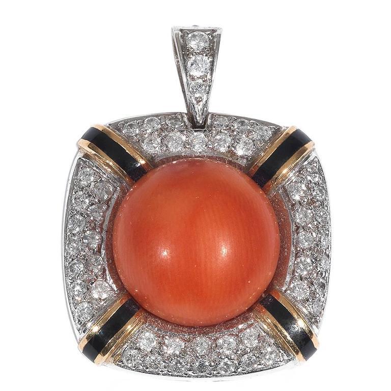 Of rounded corners square shape design centered by a round cabochon coral measuring approx. 15 mm framing by a diamond pave set and black enamel rows border.

Mounted in 18Kt white and yellow gold.

34 mm long 

Weight: 17.9 gr