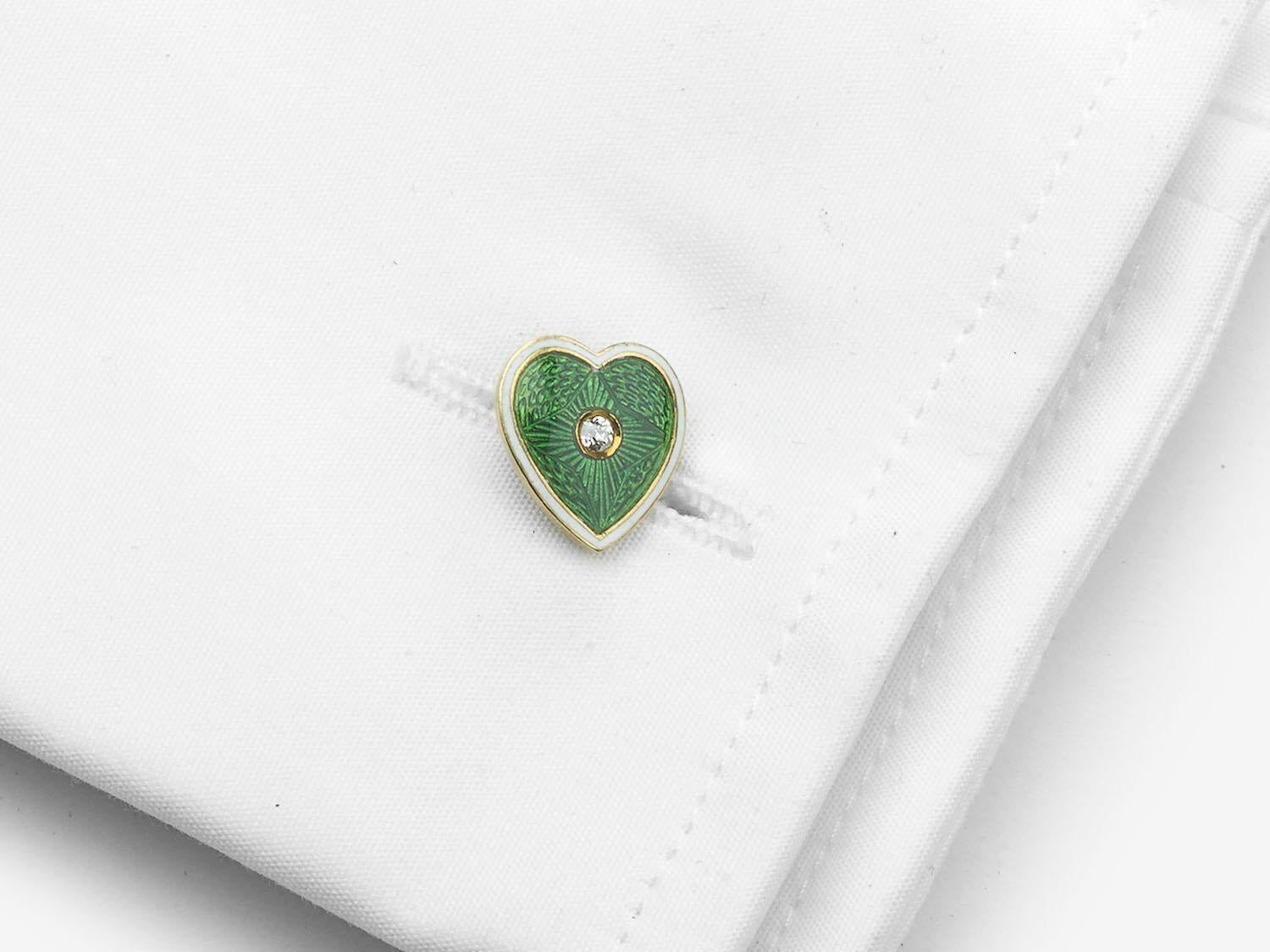 A pair of antique, green and white enamel heart shape cufflinks, with old-cut diamonds set in the centre, with surrounding green, guilloché enamel, with white enamel borders, mounted in 18ct gold, stamped 18, with chain fittings, with inventory