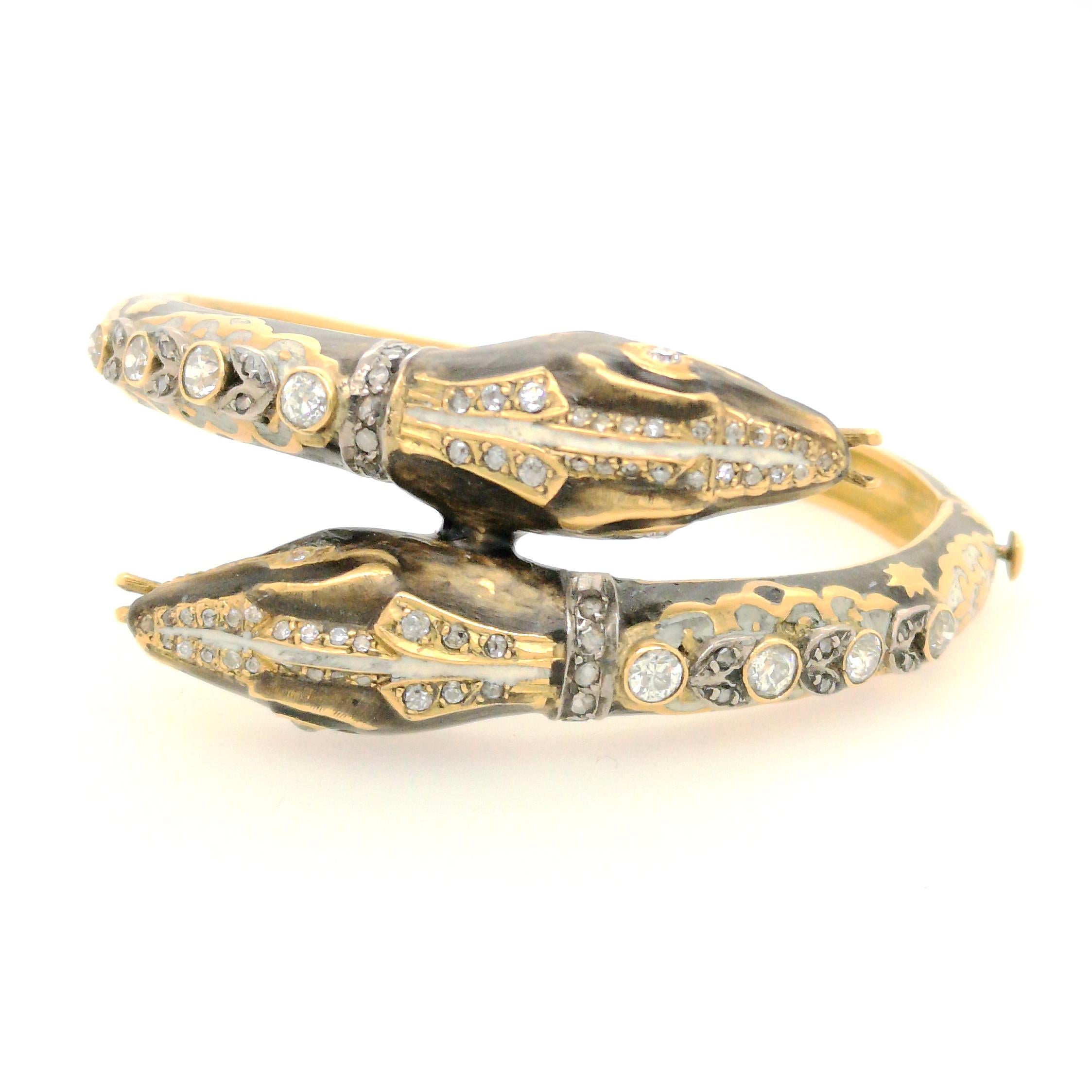 A diamond and enamel double headed snake bangle, the heads in a crossover position, set with old-cut and rose-cut diamonds, with semi-transparent black and white enamel, set around the whole bangle, mounted in 18ct yellow gold, estimated total