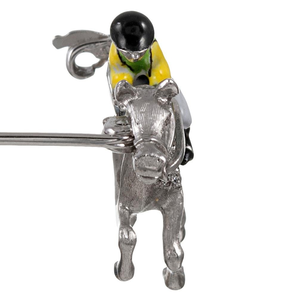 An absolutely charming enhancement for your lapel, this darling pin is made of 18 karat white gold and decorated with an enameled jockey sitting atop his diamond-set horse. Note the incredible detail, including the texture on the horse’s legs &