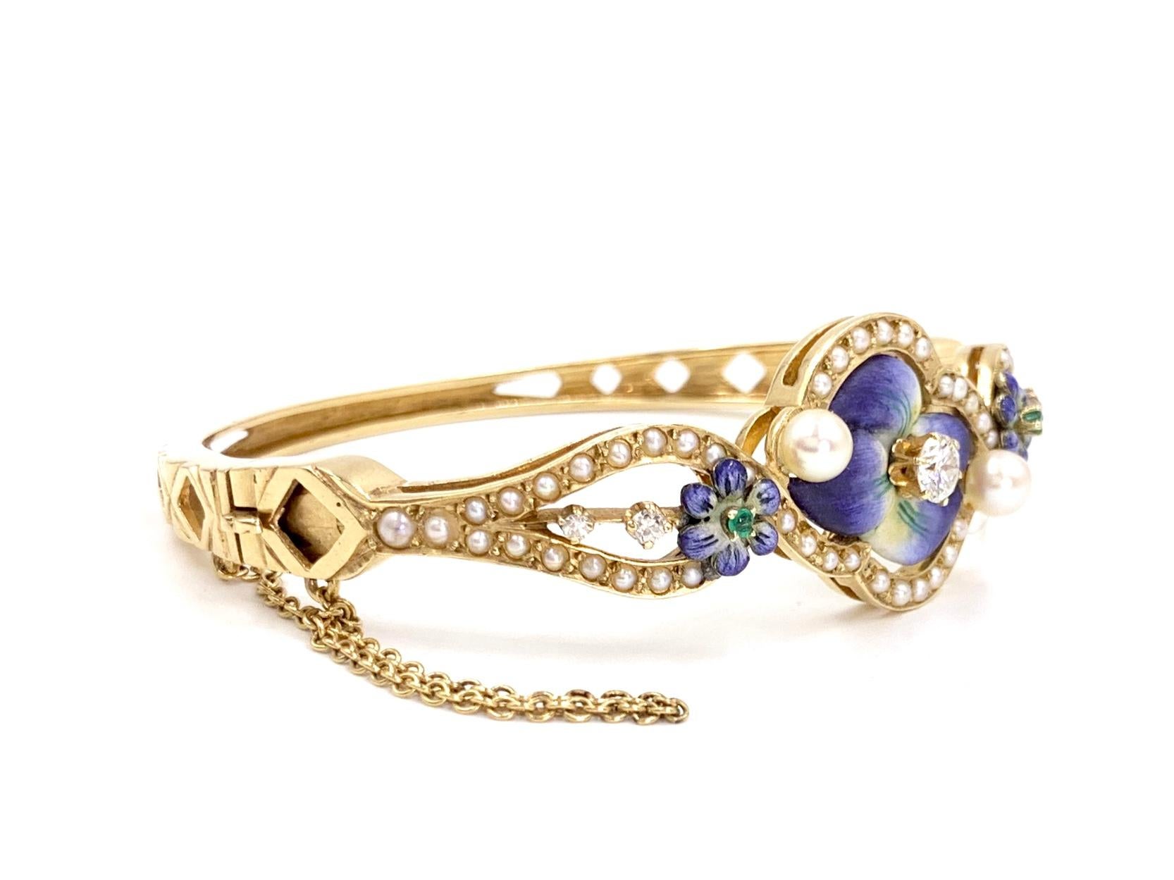 Circa 1960's, this simply beautiful 14 karat gold Victorian inspired floral motif bangle is a 
one of a kind piece featuring white diamonds, lustrous cultured pearls, hand painted enamel and emeralds. Center diamond weighs approximately .30 carats