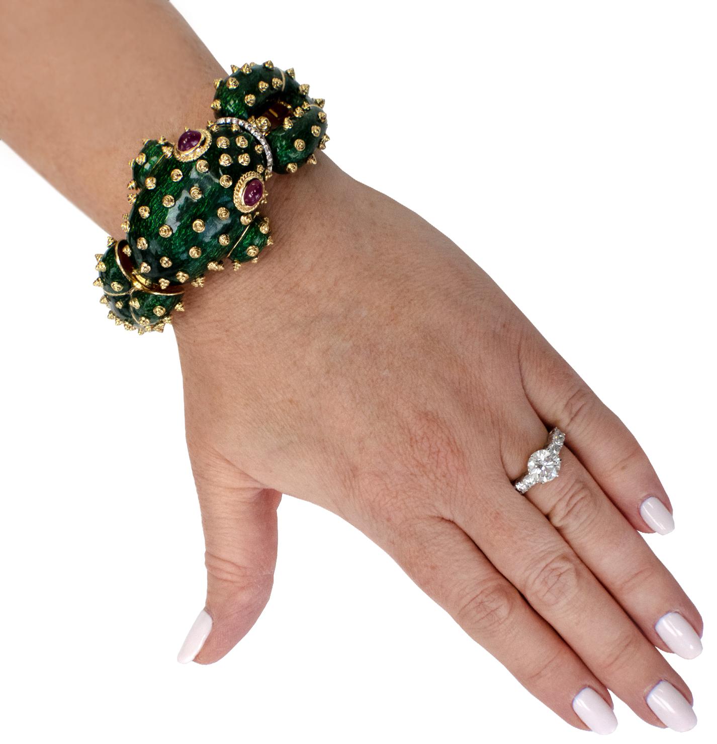 Elegantly fun, this 18karat yellow gold masterpiece boasts a vividly enameled frog, bathed in a lush shade of green and dotted with glistening gold nodules. Its lips sparkle with 16 brilliant round-cut diamonds, approximately .25 carats in total, F