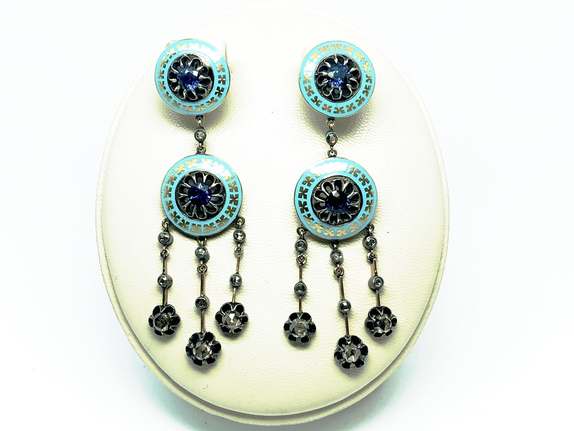 A pair of drop earrings, turquoise enamel ring, set with gold X's to the circle and set with a sapphire to the centre, suspending a further larger circle of the same design and three drops, each set with three brown rose-cut diamonds, mounted in