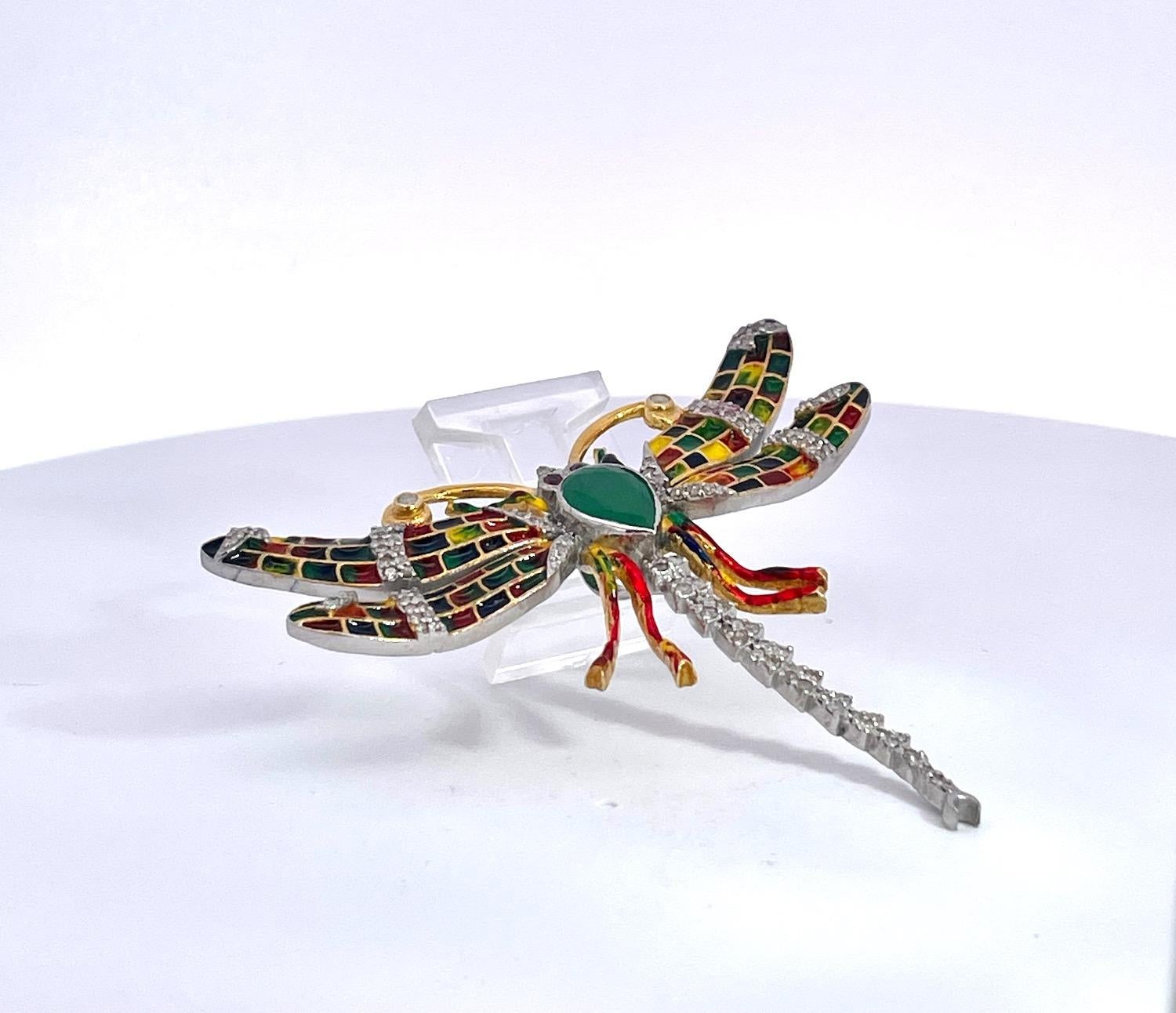 Este colorido broche de esmalte está realizado tanto en platino como en oro amarillo de 14 quilates. Mide 6 cm de ancho y 5 cm de largo y pesa 13,43 gramos.  Tiene ojos de rubí y la cornamenta está tachonada de diamantes.  El cuerpo es una Esmeralda