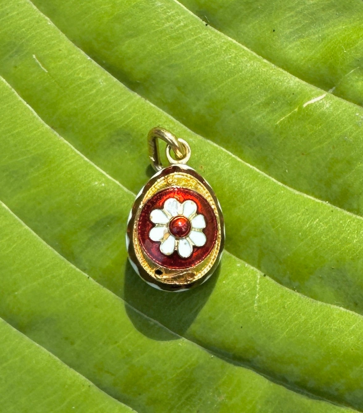 This is an extraordinary antique Enamel Easter Egg 18 Karat Gold Pendant or Charm.  The fabulous egg has beautiful red and white enamel designs with a flower motif in the center and a diamond design border around the egg.  The egg is further adorned