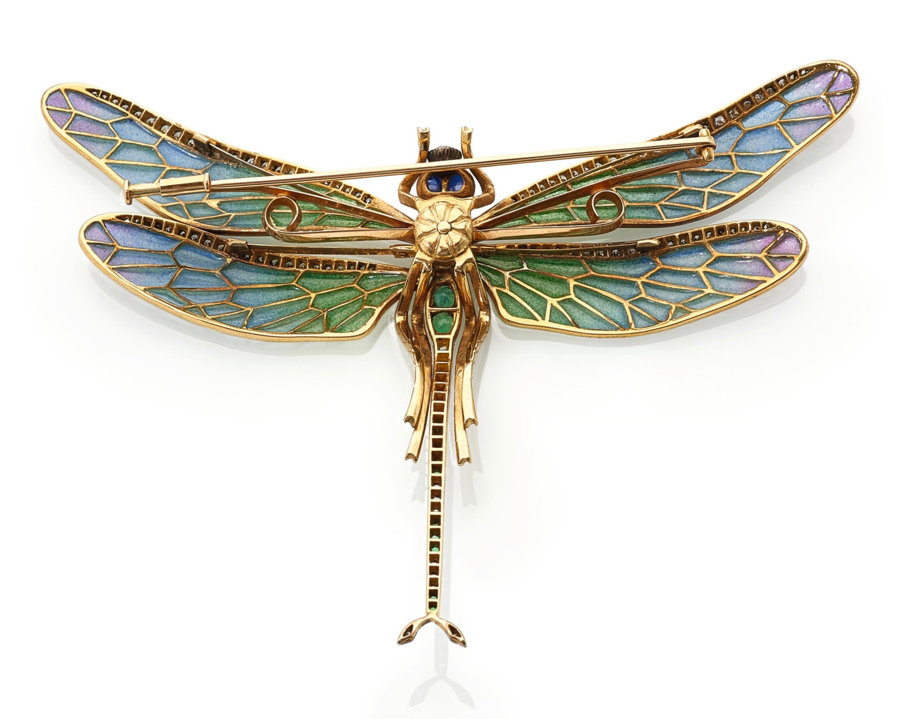 Designed as a dragonfly, the body set with circular-cut emeralds and diamonds, eyes highlighted with cabochon sapphires to en tremblant wings applied with plique-à-jour enamel and circular-cut diamonds, gross weight 34.7 grams. Approximately 3CT