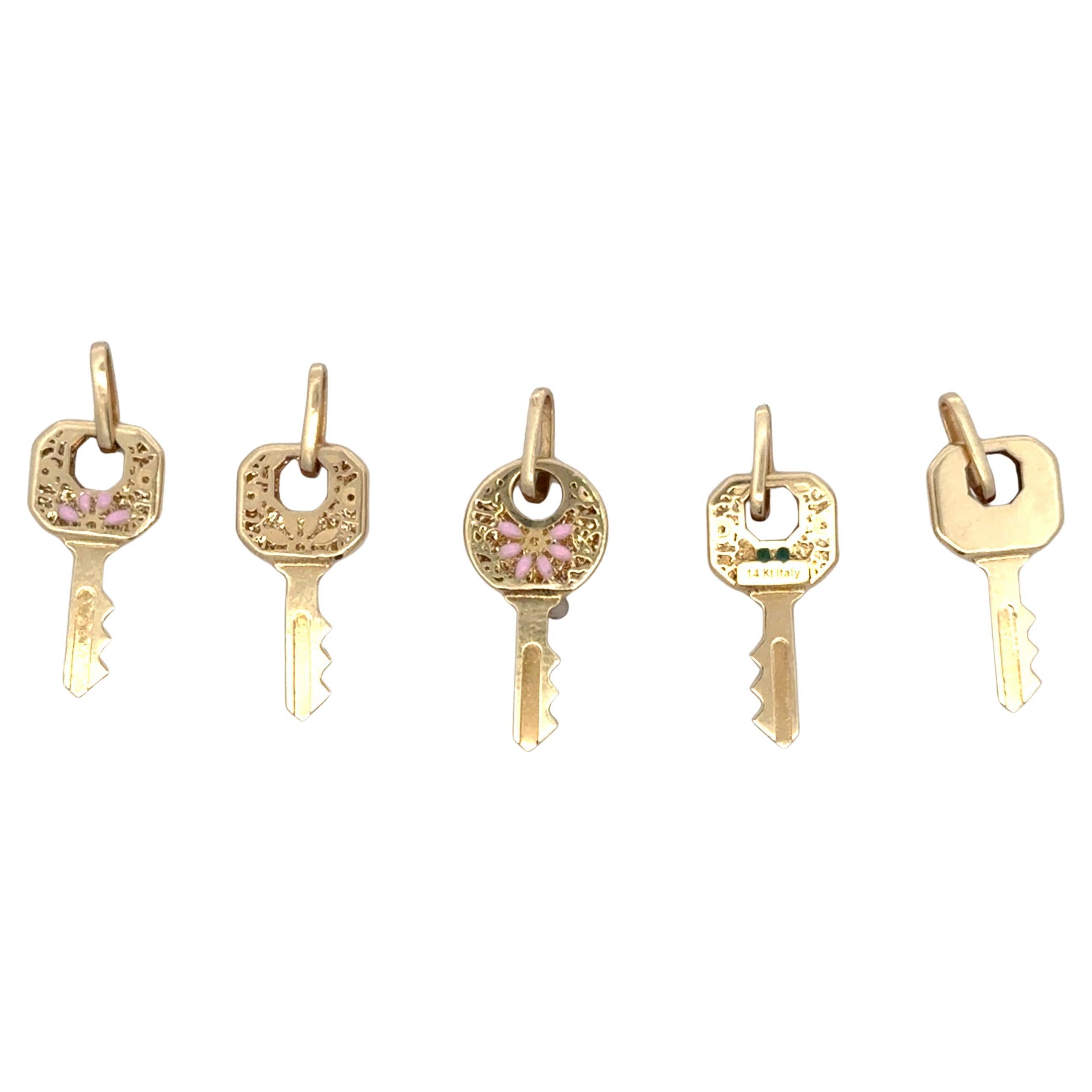 Fabriqué en Italie, ce pendentif en or jaune 14 carats à motif de clé est disponible en deux tailles. Les plus grandes sont en or simple et les plus petites sont ornées d'un motif floral en émail.
Fourchette de 0,7 à 1,4 grammes 
Prix illustré pour