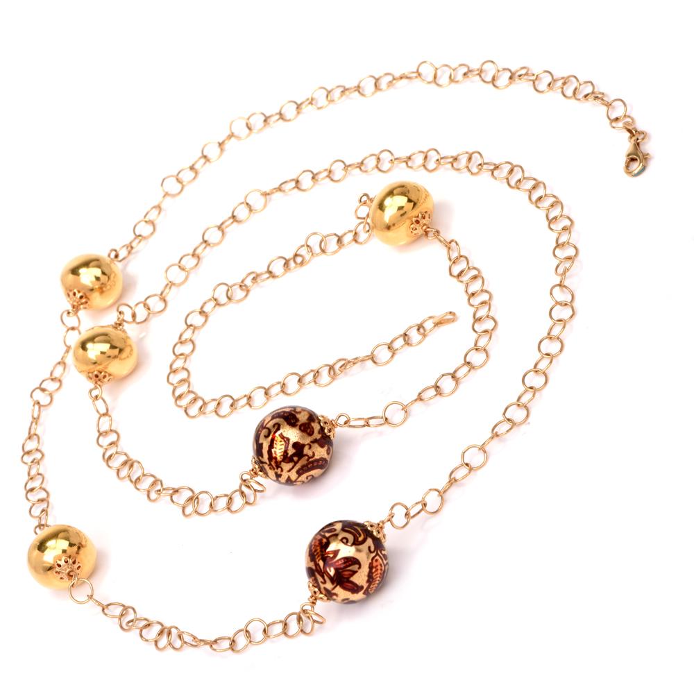 This stylish chain necklace of considerable length is crafted in 18-karat yellow gold, weighs 28 grams and measures 39 inches long. It incorporates inversely juxtaposed interlocking round links intersected by 6 yellow gold beads of 2 distinct sizes,