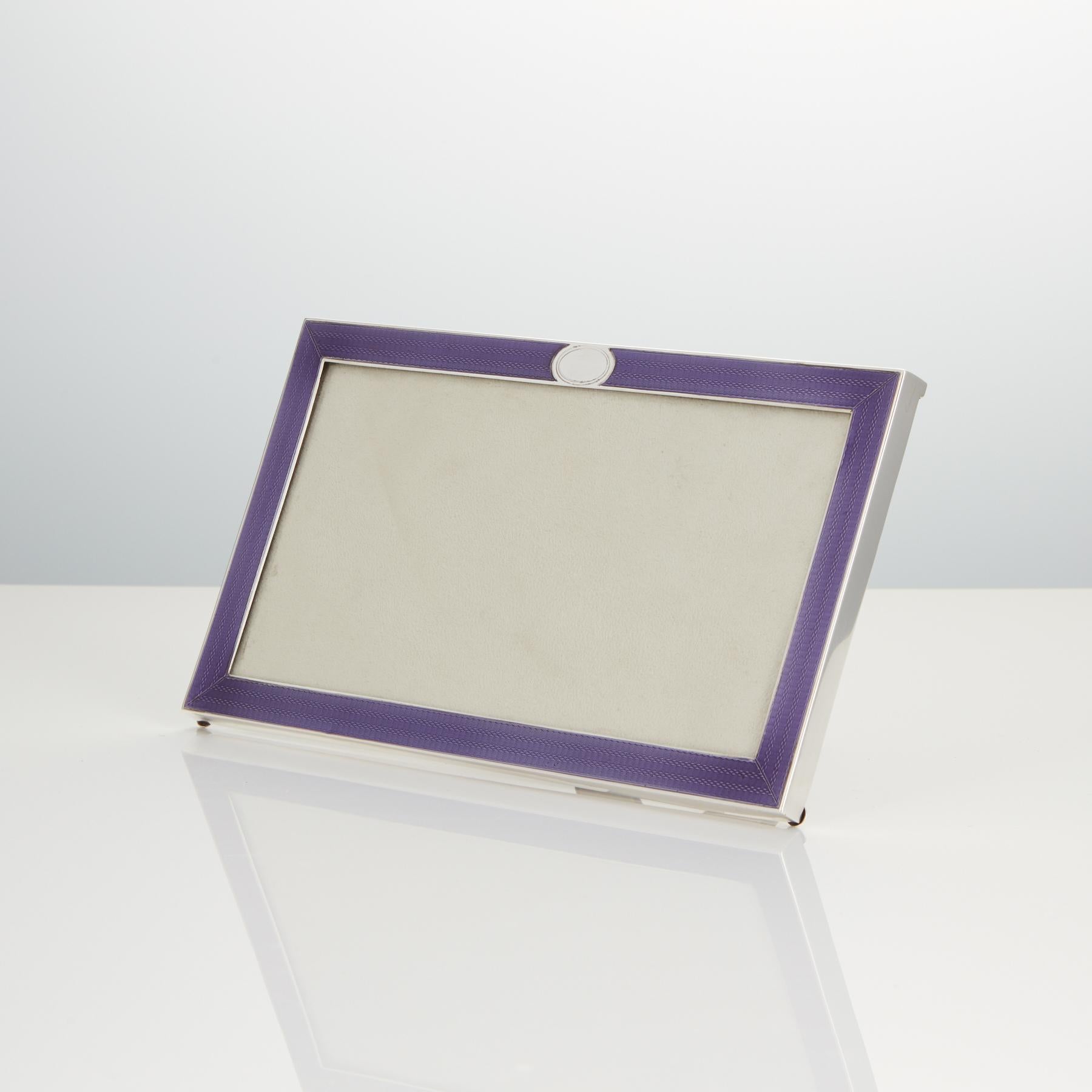 This stunning mauve enamel photograph frame retains the original condition and high iridescent quality of the enamel. 

The back and easel strut are also in original condition.

Maker Goldsmith & Silversmith Co Ltd. The firm was established in 1880