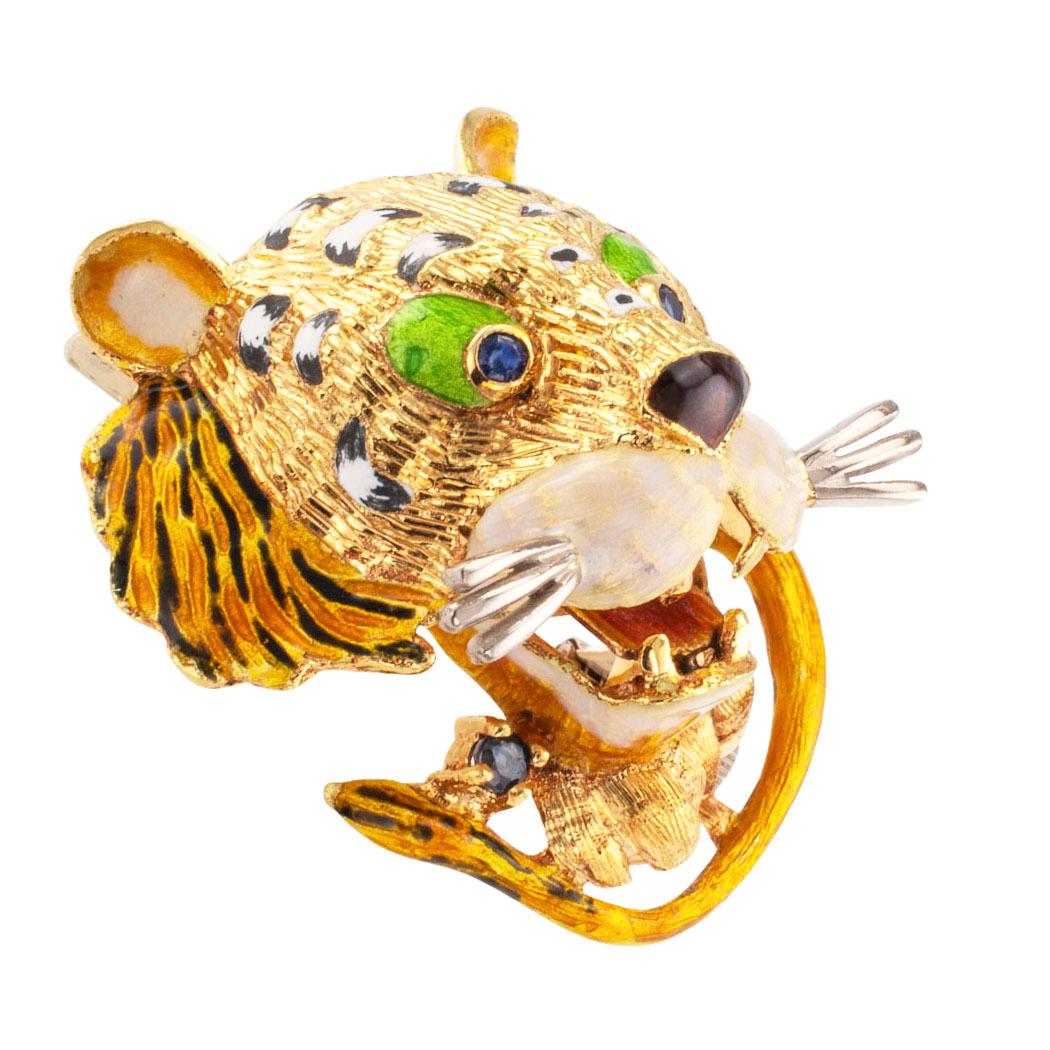 Enamel tiger brooch with sapphires mounted in 18 karat gold circa 1960. The design features the head, tail, and front paws of a tiger seemingly lunging forward, decorated with enamel, 
and sapphire eyes, mounted in 18-karat gold. It is beautiful and