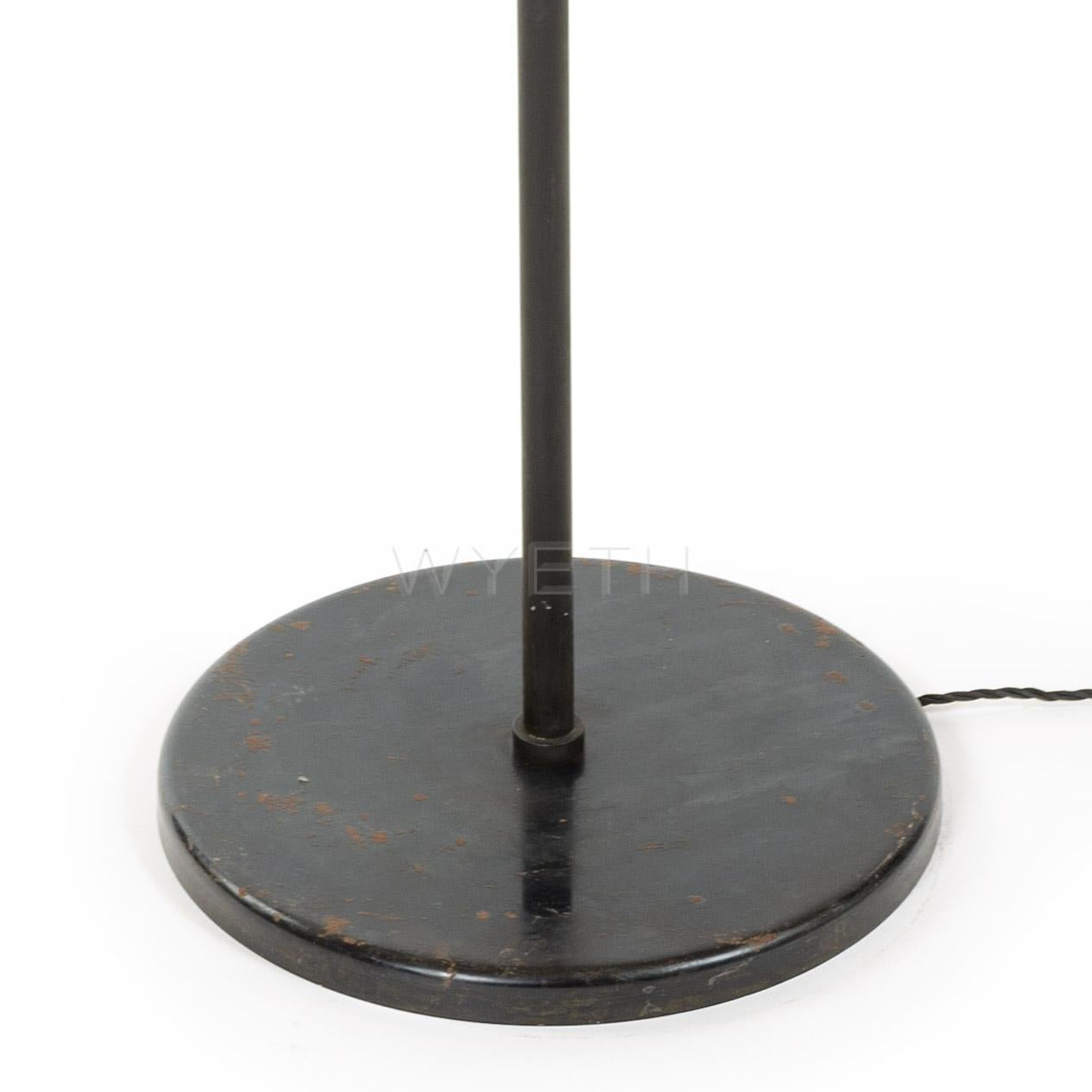 Lampadaire en acier émaillé noir avec trois bras en laiton supportant un réflecteur et un abat-jour en acier perforé.