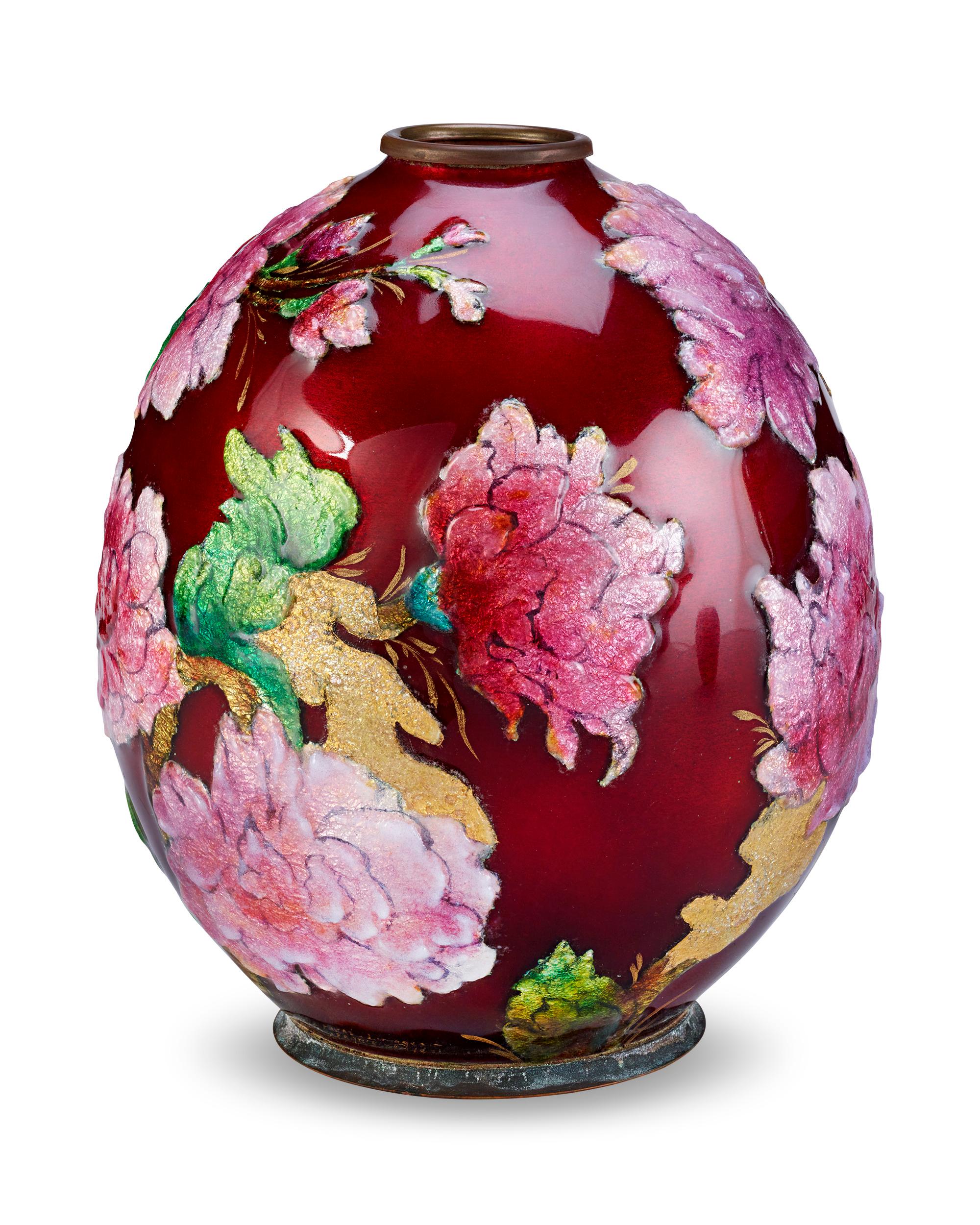 Delicate pink flowers burst forth from a vibrant red ground in this enameled vase by Camille Fauré. Executed using his signature technique, the vase's copper form is covered in the silver leaf and richly colored enamel that give Fauré's pieces their