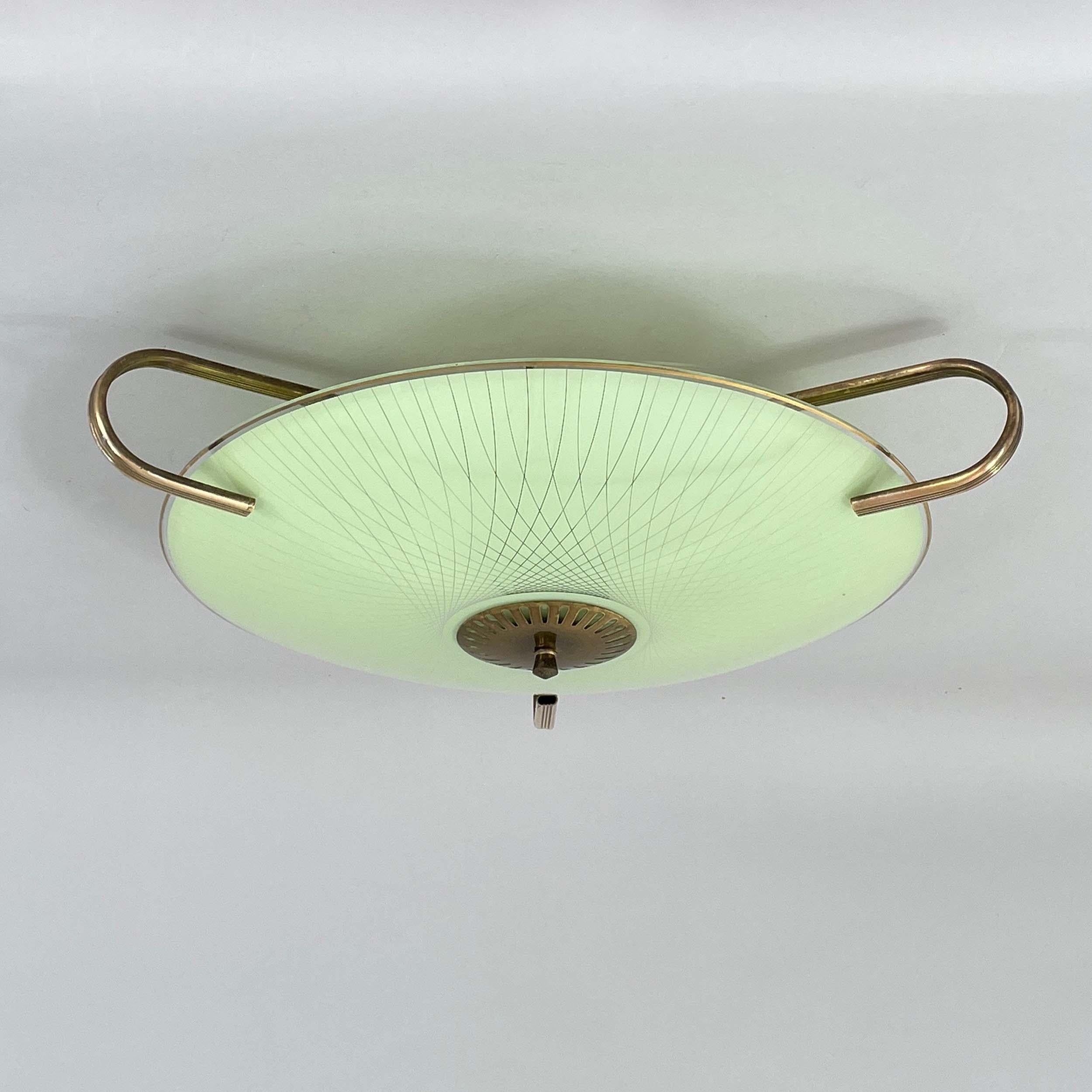 Designer allemand, style Art déco tardif, années 1950.

La lampe présente un abat-jour en verre rond, légèrement convexe, d'une douce couleur vert clair, avec un motif radial gravé émanant du centre. Le luminaire est rehaussé d'une quincaillerie en