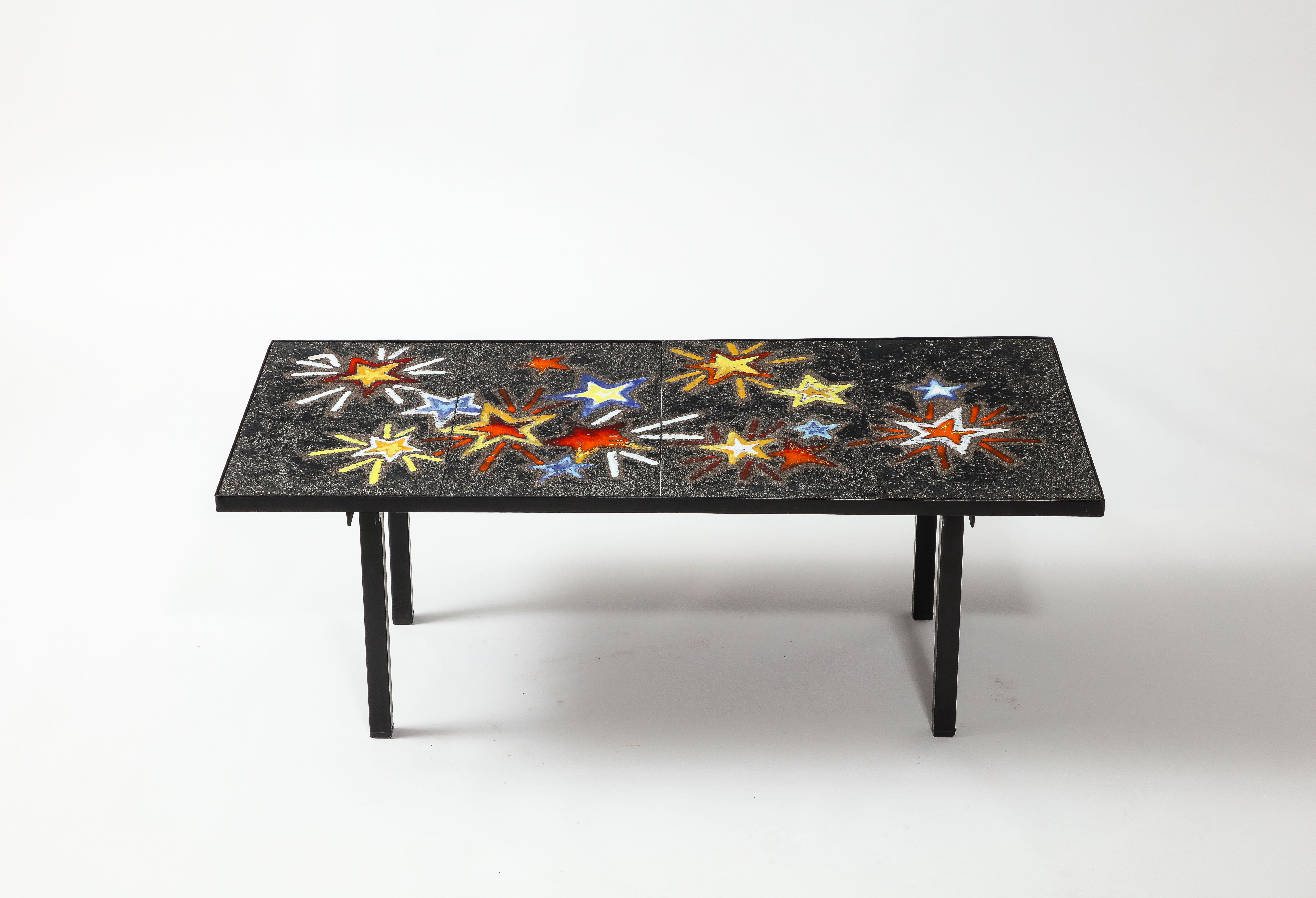 Table basse fantaisiste en acier avec carreaux de lave émaillés d'étoiles filantes multicolores.