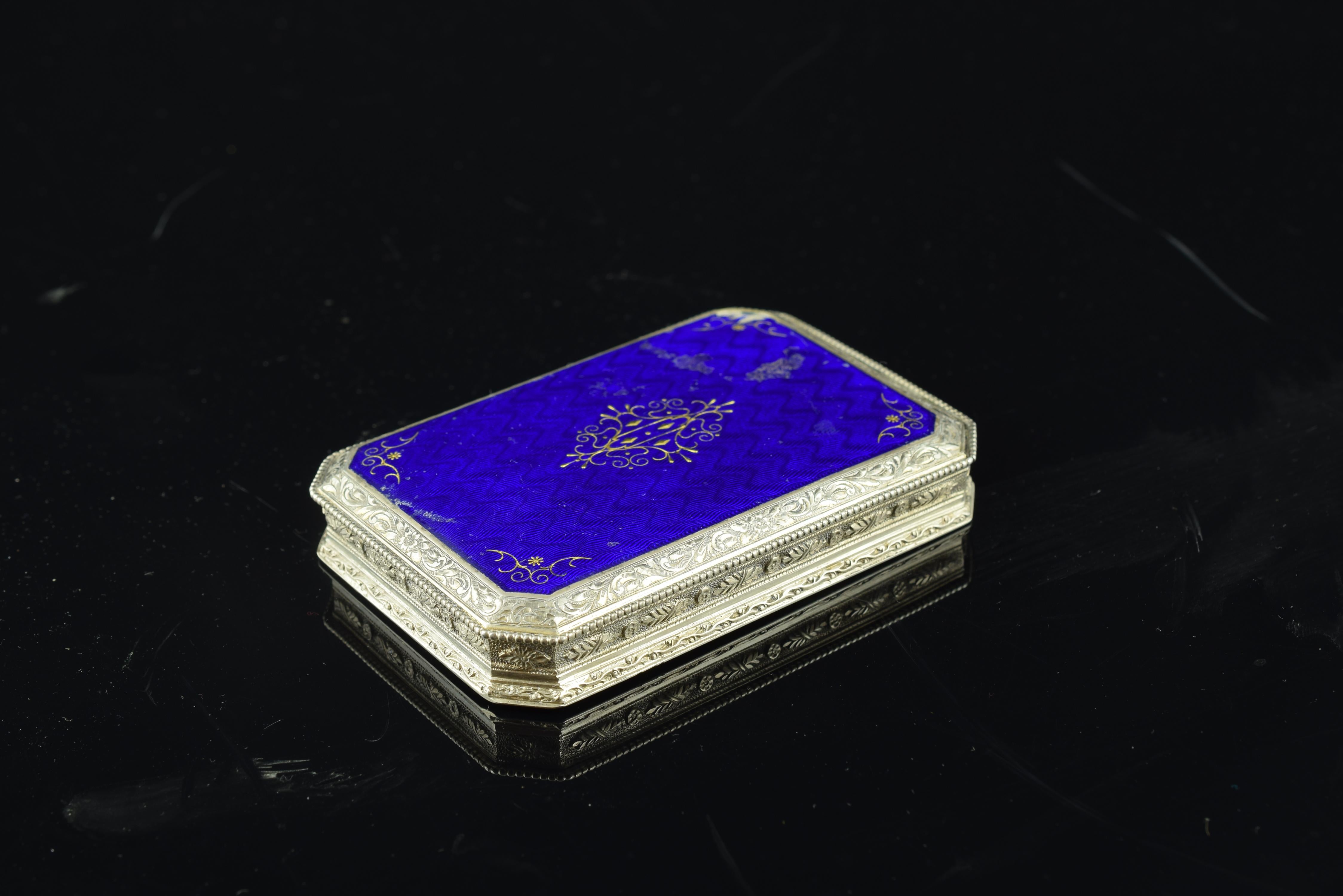 Enameled silver box with, 19th century. With hallmarks.
Rectangular box with attached lid hinge stands out for its blue CAP with very stylized plant elements in gold. The rest of the surface of the part is decorated by plant but also reasons more