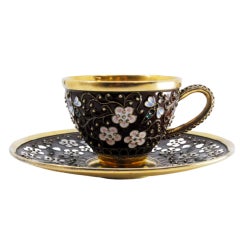 Enameled silver cup and saucer with floral motifs and gold interior