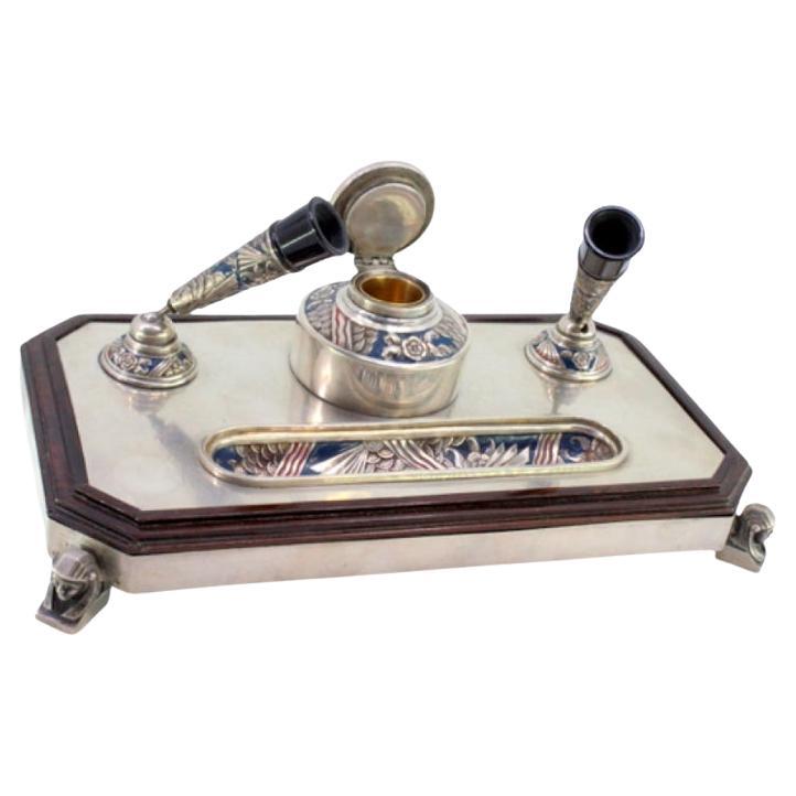 Enameled silver inkwell on wood with reservoir 
sphinx-shaped feet