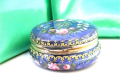 Enameled silver pill box with applied floral motifs and gold interior