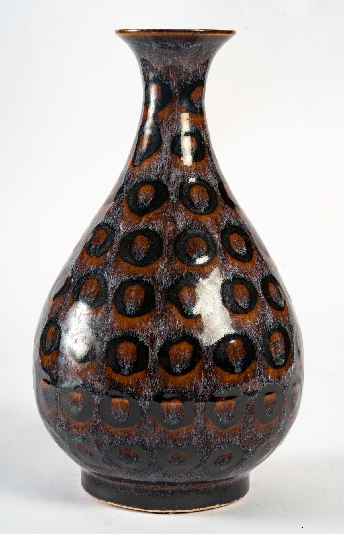 An enamelled stoneware vase with a rare ocellated decoration of rust and black on a shaded grey background.
China, Republic period. No damage. 
Measures: H: 31 cm, D: 17 cm.