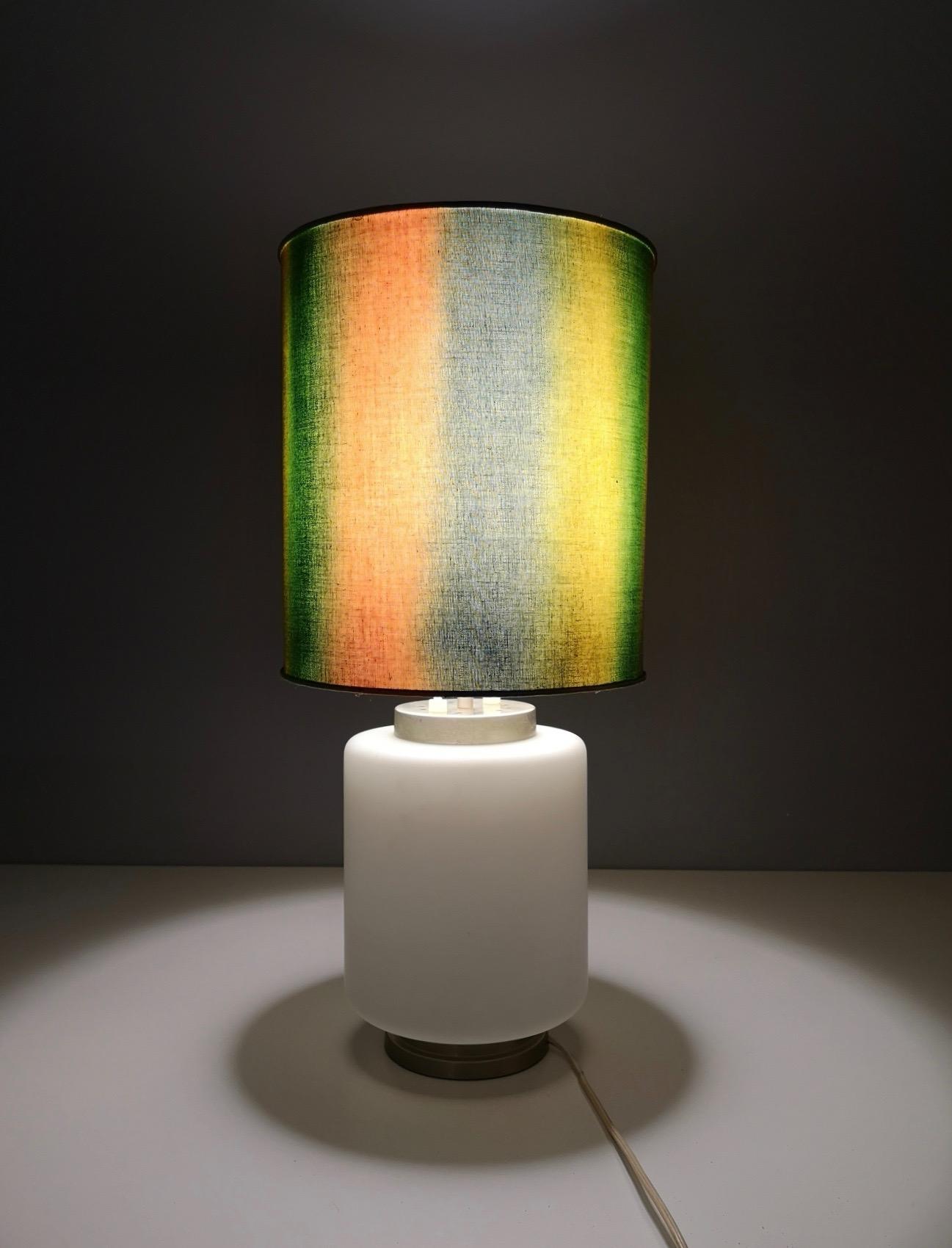 Made in Italy, 1960s.
It is made in encased glass, metal and fabric. 
This table lamp features two lights: they can be switched on separately or at the same time. 
It might show slight traces of use since it's vintage, but it can be considered as in