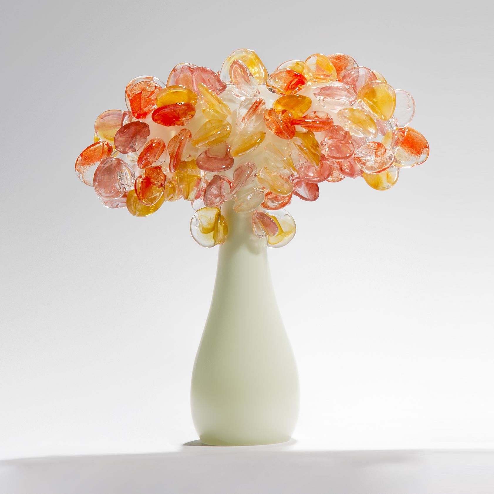 Enchanted dusk in short coral, is a unique glass tree sculpture by the British artist Louis Thompson. The initial tree trunk form has been hand blown in clear and ivory/alabaster colored glass. The top has been covered in free-hand sculpted leaves,