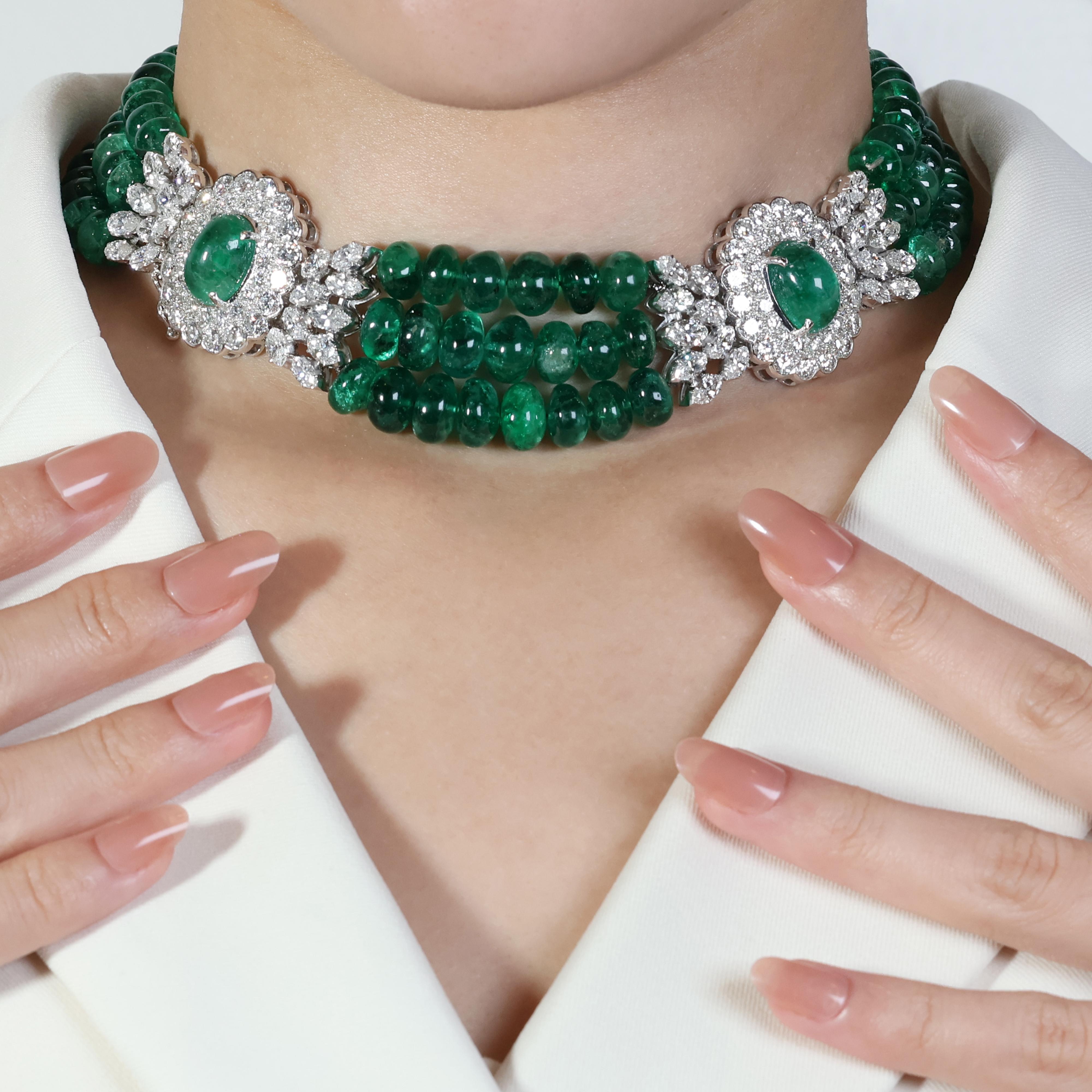 This captivating necklace showcases a breathtaking display of emeralds and diamonds, meticulously set in luxurious 18K white gold. The centerpiece features two mesmerizing cabochon emeralds boasting a combined weight of 16 carats and 143 pieces of