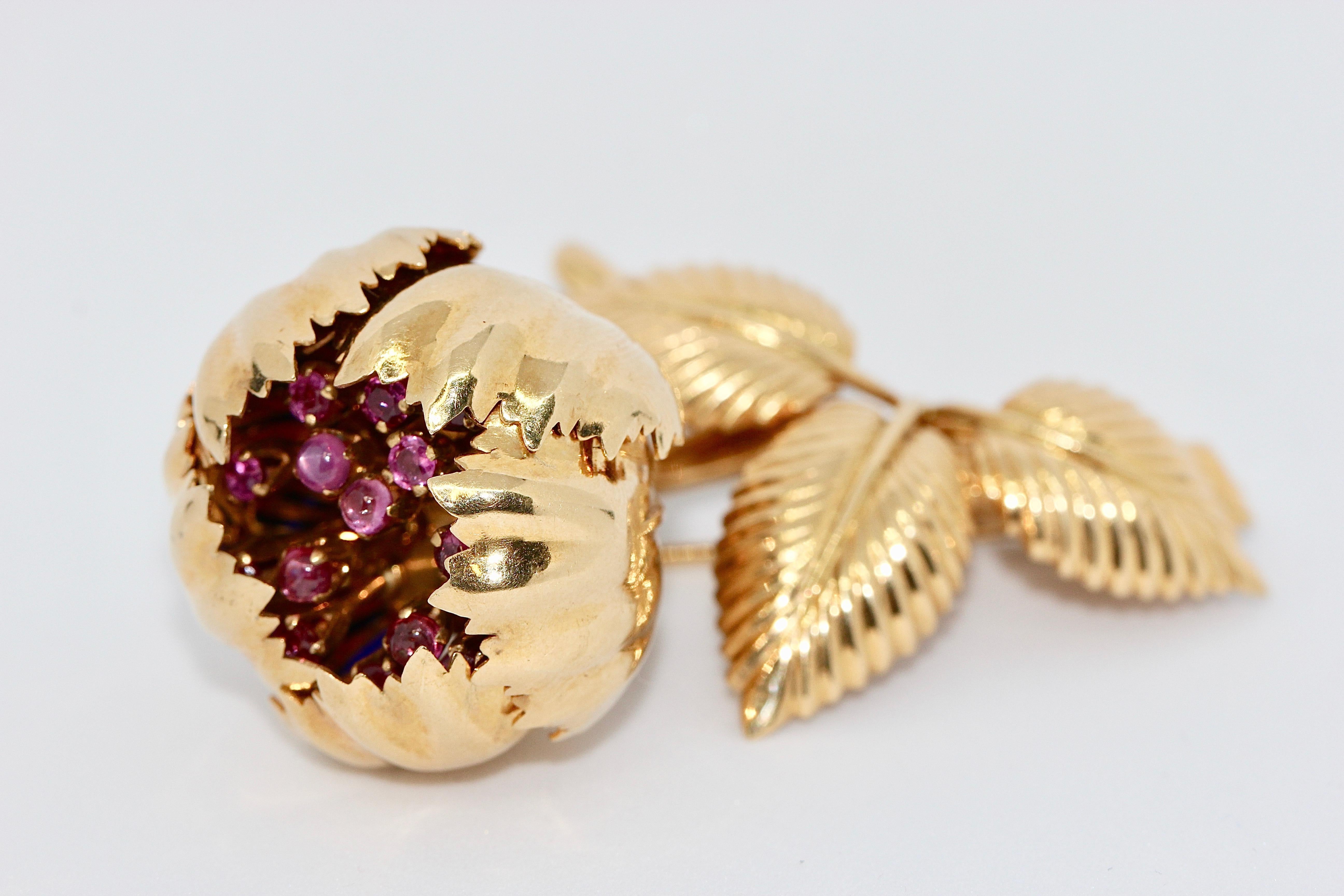 Enchanting, 18 Karat floral gold brooch with movable petals, rubies and enamel.

Extremely high quality goldsmith work. Probably a single piece. 

The five large petals can be opened and closed around the ruby stems.
Inside of the leaves with enamel