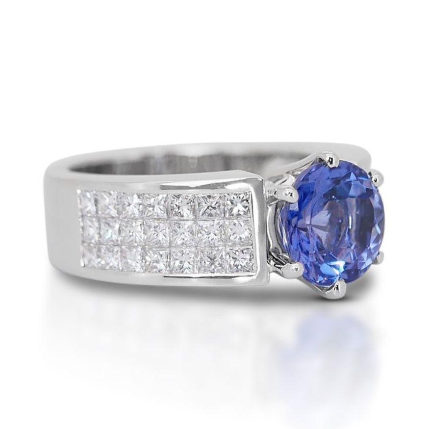 This enchanting ring features a dazzling round mixed-cut tanzanite as its centerpiece, weighing 1.90 carats. The tanzanite displays a deep violetish blue hue, evoking a sense of mystery and allure. With its transparent clarity, the tanzanite allows