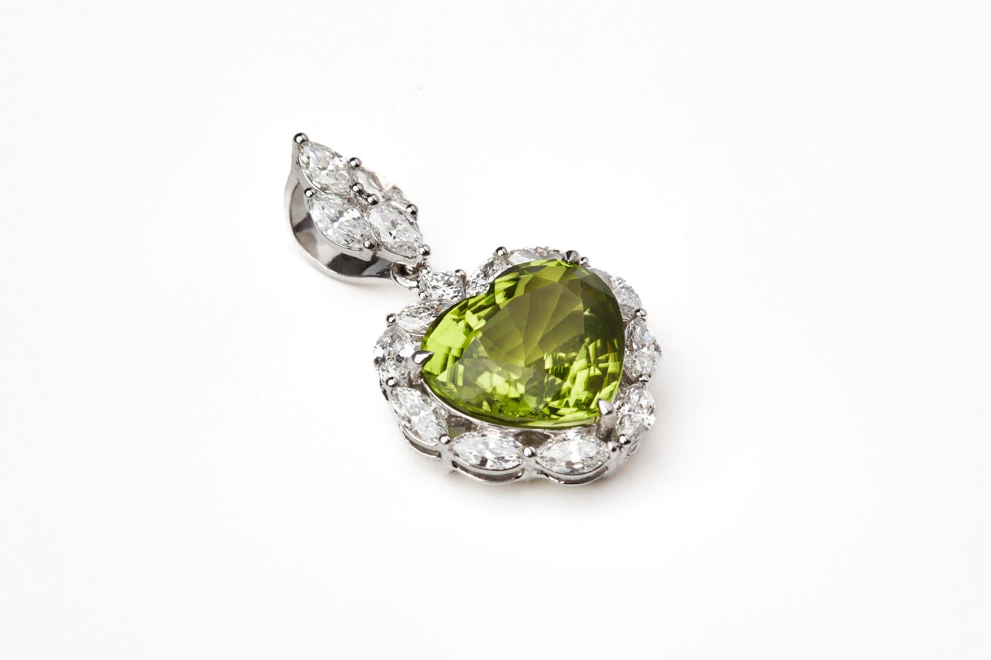 OR BLANC 18 CARATS
1 DIAMANT ROND   0,07 CARATS
14 DIAMANTS MARQUIS   1,56 CARATS
1 PÉRIDOTS DE BIRMANIE  6.21 CARATS 

Voici notre délicieux pendentif en forme de cœur en péridot, une célébration de la joie et de l'énergie vibrante. Au cœur de ce