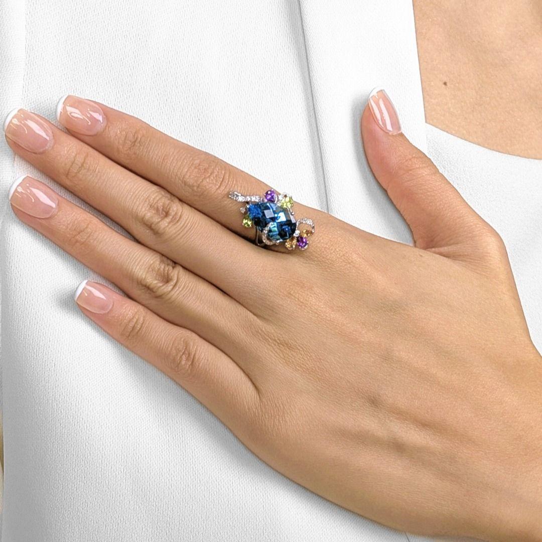 Llama la atención con este majestuoso anillo, coronado por un impresionante topacio azul de 8 ct en forma de pera que irradia un brillo oceánico. Alrededor de la pieza central hay 6 gemas mixtas (0,53 ct en total) en tonos vibrantes, que añaden un