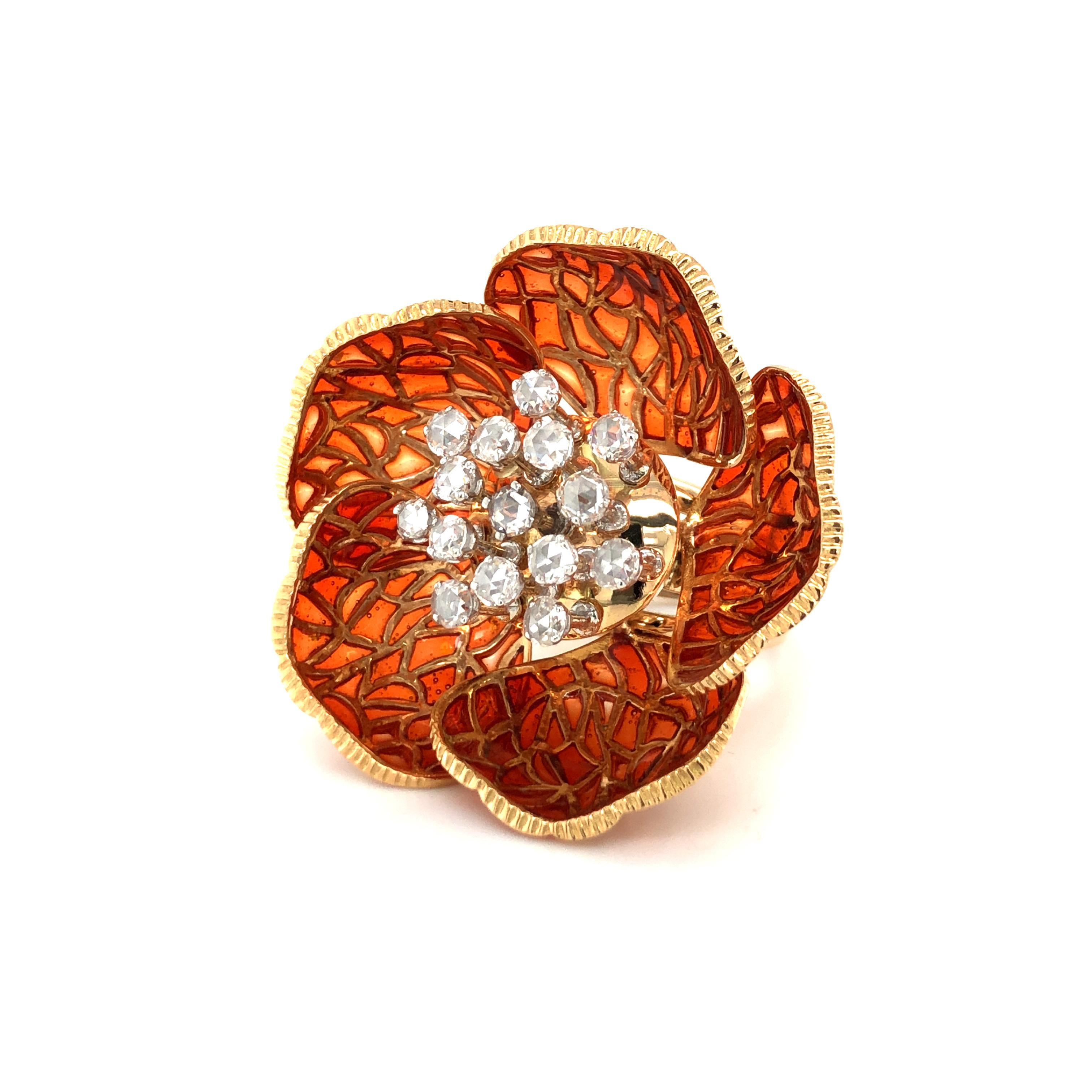 This spectacular flower ring in 18 karat yellow gold is in full bloom, the seven leaves, decorated with orange enamel, wide open. This enameling technique is called 'plique à jour' and allows the light rays to shine through the enamel.
In the centre