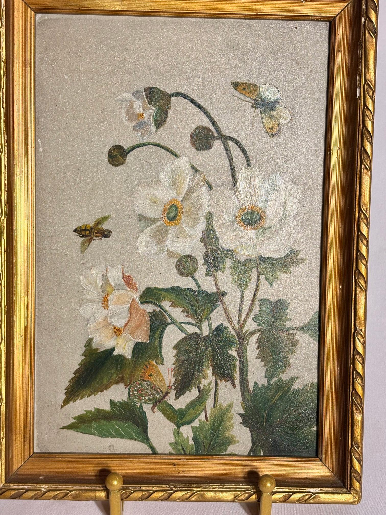 Dieses schöne Vintage-Stillleben zeigt zarte weiße Blumen und grünes Laub.  Umgeben von flatternden Schmetterlingen und vor einem gedämpften Hintergrund hat dieses Stück eine zeitlose, botanische Ausstrahlung.