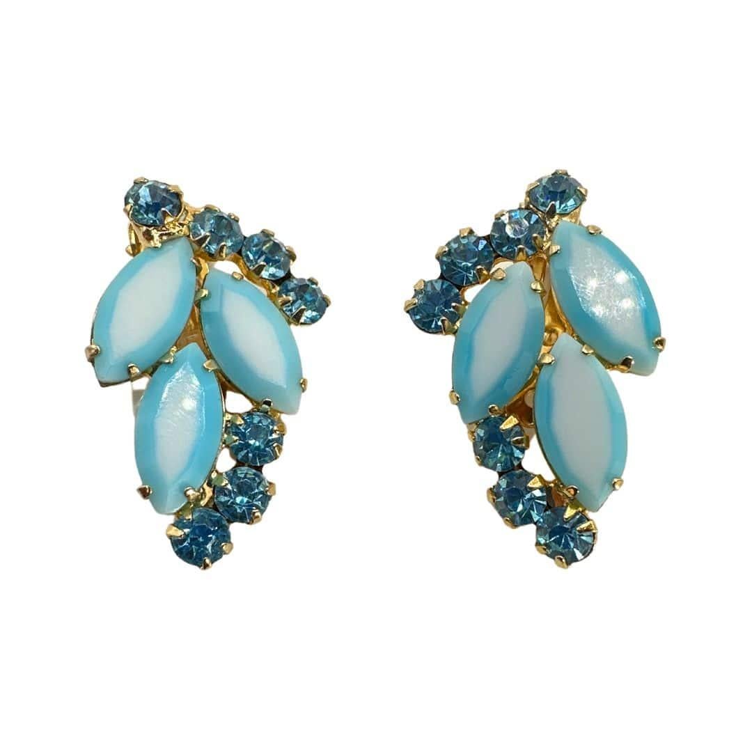 Trasportati in un'epoca passata con il nostro affascinante set di spille e orecchini in vetro vintage blu e bianco. Questo delizioso insieme mette in mostra l'ipnotica bellezza del vetro ombreggiato in una splendida combinazione di spilla e