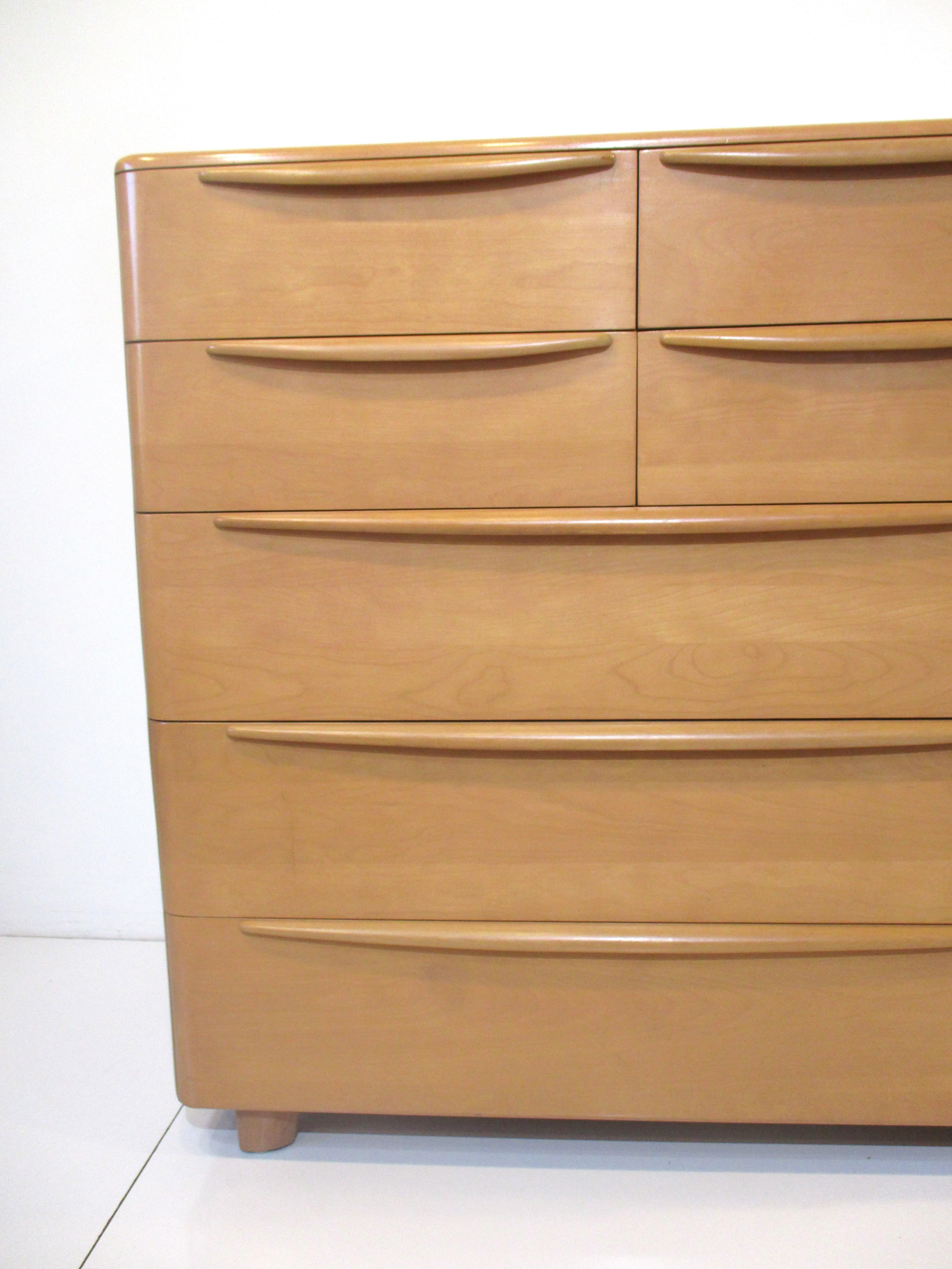 A very well crafted solid maple wood double dresser chest with four smaller drawers to the top and three larger ones to the bottom. Streamline pulls run the length of each drawer top and rounded corners give the piece that nice simple smooth look