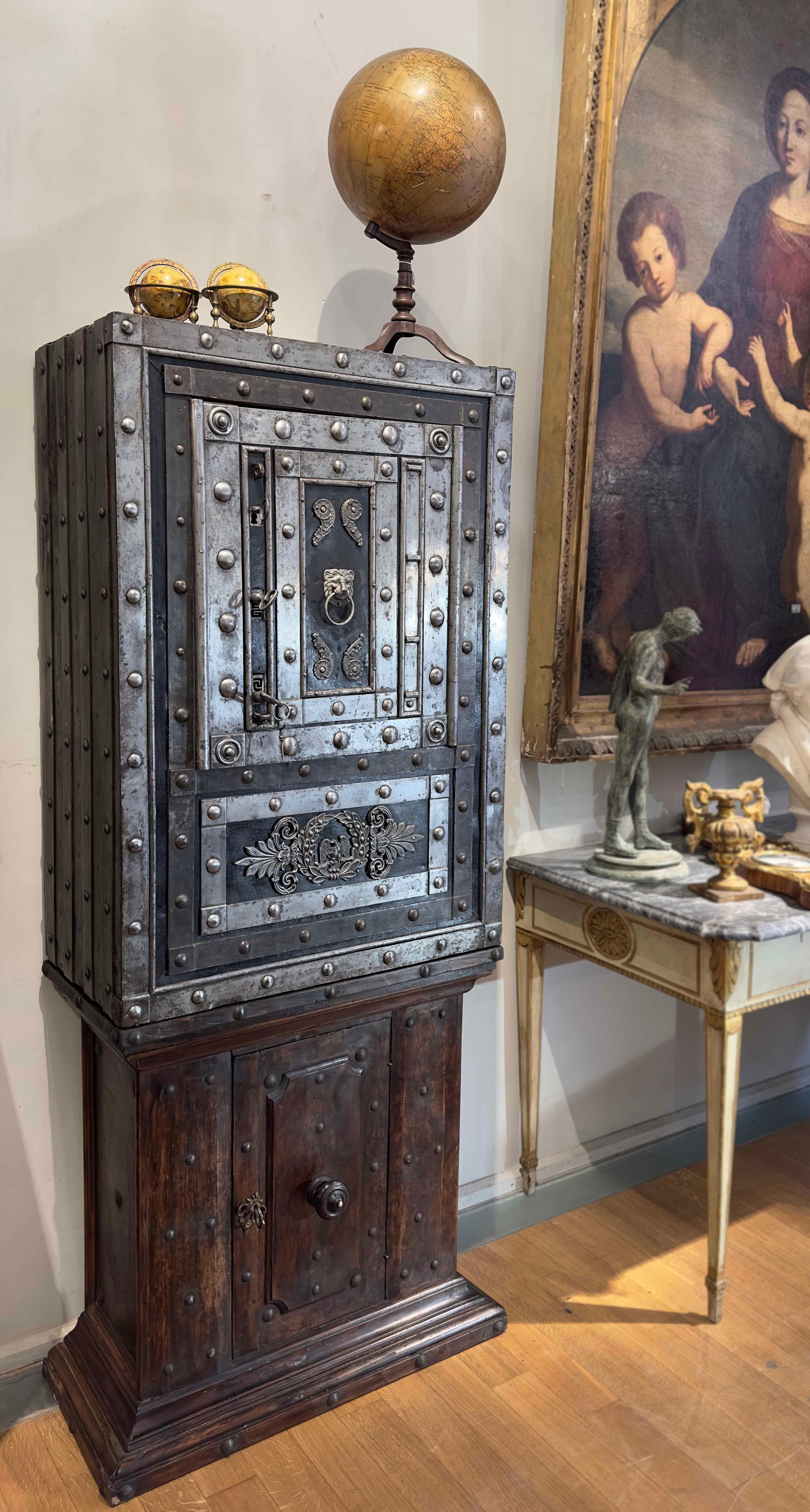 Beautiful iron safe from the late 18th century, mounted on an elegant Louis XIV small sideboard in solid walnut wood. This safe is particularly interesting for its construction with iron and steel plates fixed with bolted, rounded-head nails stuck