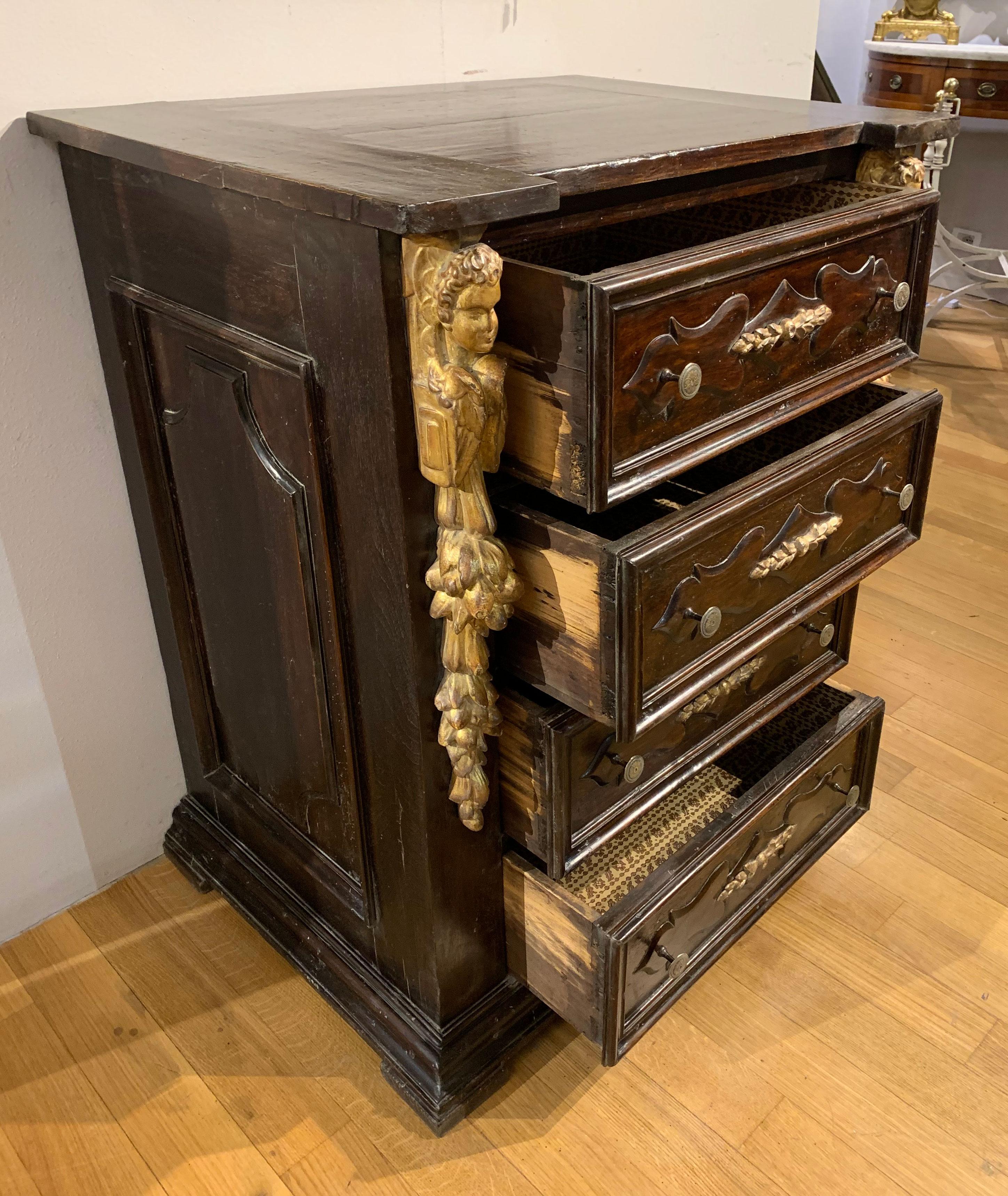 Schöne Kommode aus Nussbaum im Renaissancestil mit kleinen Abmessungen, die sich durch Schnitzereien und Paneeldekorationen sowohl an den Schubladen als auch an den Seiten auszeichnet. Das Möbelstück ist mit den für Möbel der Hochkultur typischen