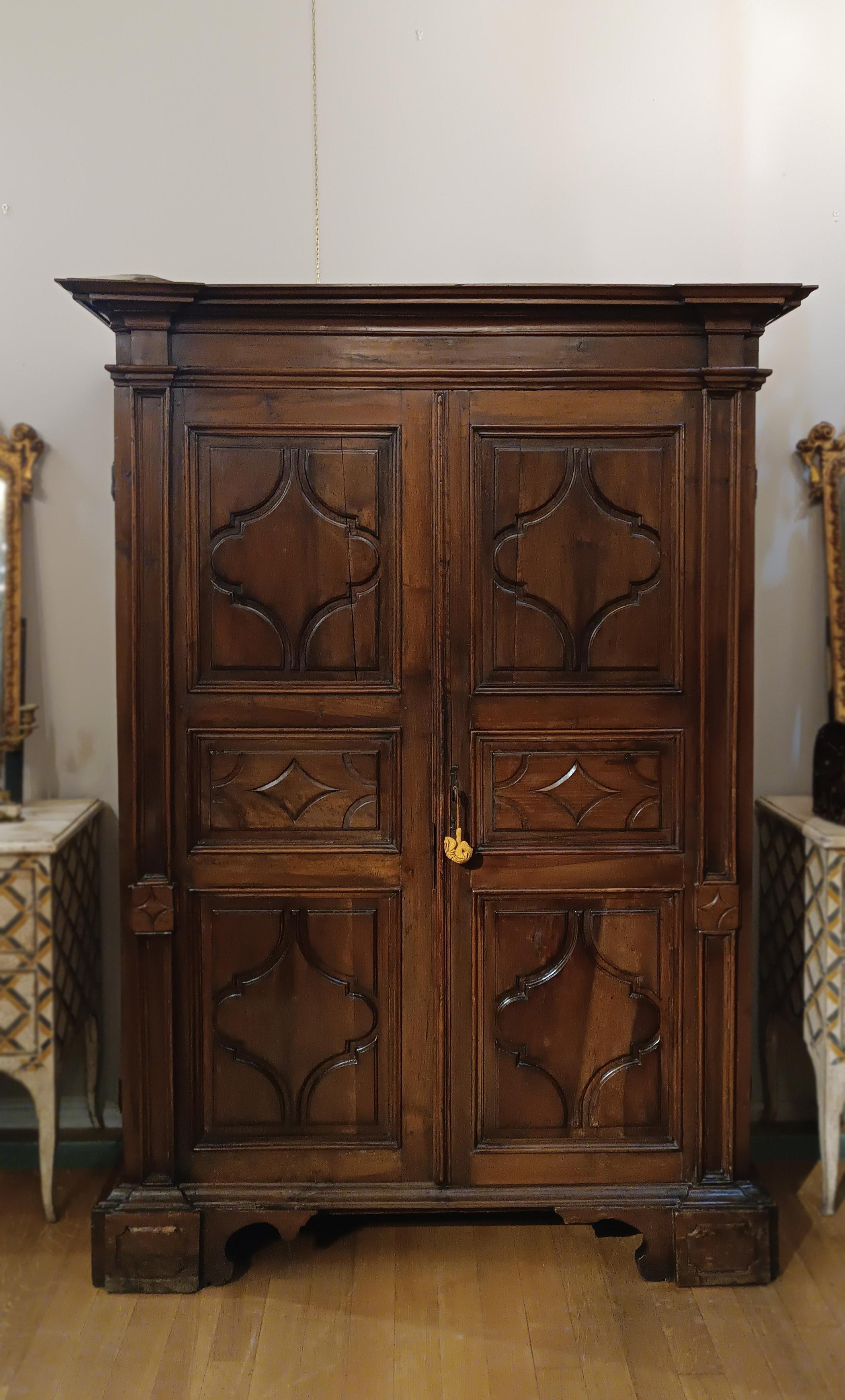 Beautiful wardrobe made entirely of solid walnut, with doors and sides finely carved with geometric tiles, which give an elegant and sophisticated decorative effect. The hat has a simple line, while the legs, rectangular but accurate in finish, give